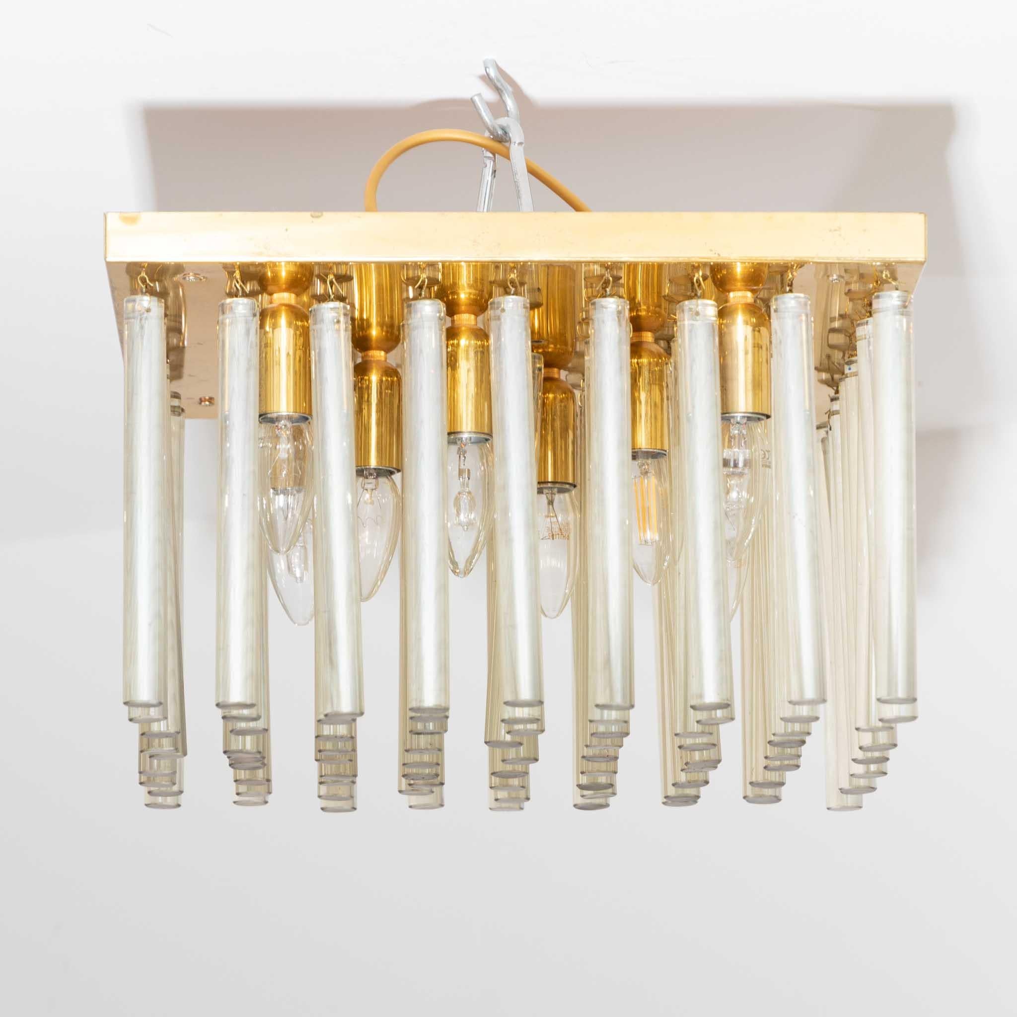 Ceiling chandelier with Tondo-shaped glass rods and square base plate in brass.