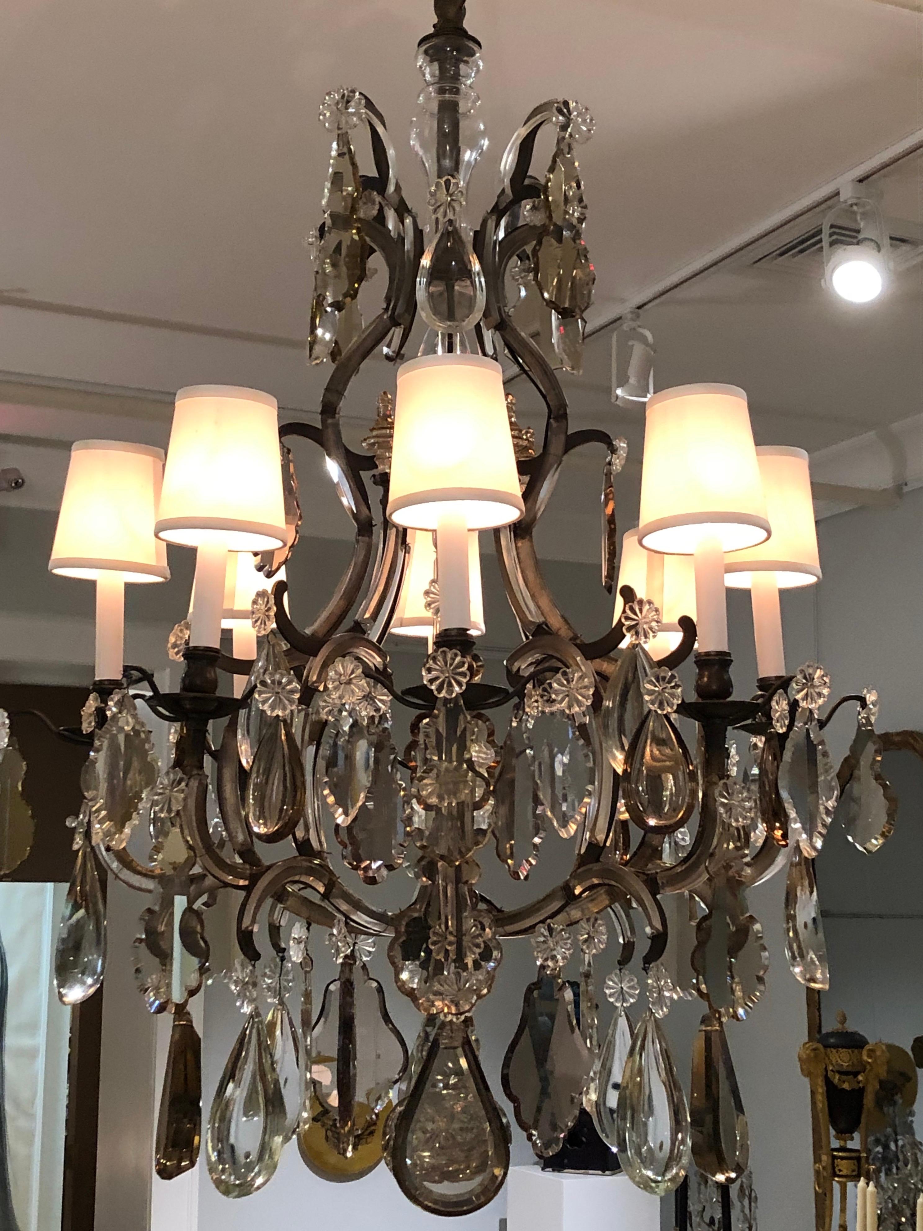 This 1930s French chandelier adapts an Ancien Régime form to Café Society taste. The arms are trimmed with cut-glass arabesques, the frame is steel rather than ormolu, and it's festooned with prisms cut from thick slabs of clear and bronze crystal.