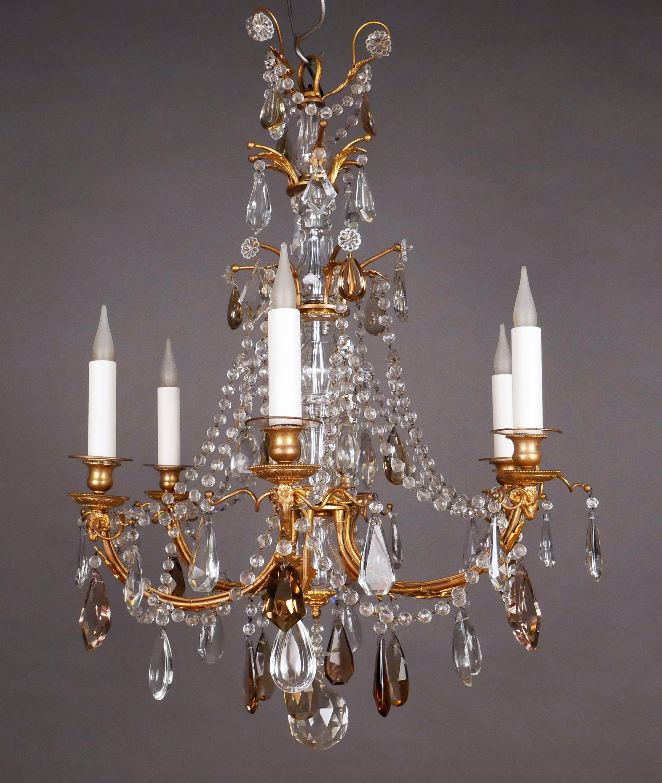 Charming Louis XVI style chandelier in gilded bronze, clear and amber cut crystal with six lights.
The central shaft, formed by a succession of balusters in cut and faceted crystal, is connected to the light-arms by garlands of pearls. The beaded