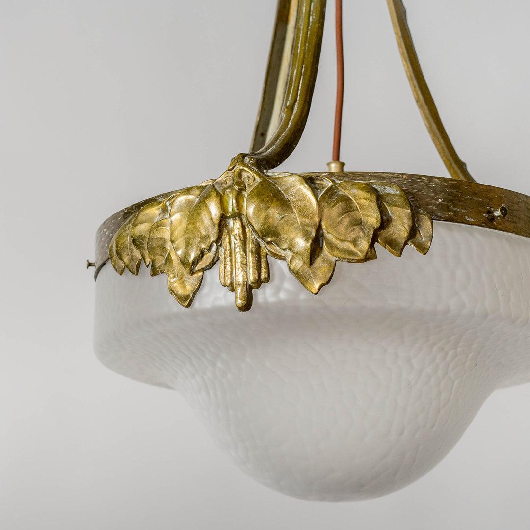 Chandelier / ceiling light in bronze with glass shade. With decor of leafs. Made by Böhlmarks, Sweden circa 1910. 

In good condition, smaller signs of age and wear