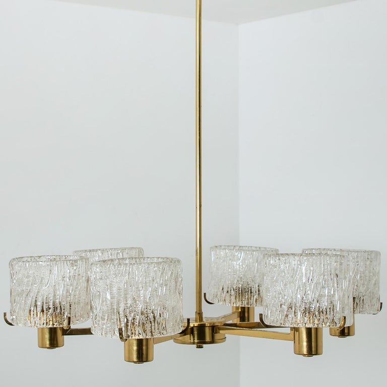 Chandelier designed by Carl Fagerlund for Orrefors, Sweden. Consists of six crystal handmade glass diffusers on polished brass arms. Manufactured in the 1960s. Designer by Carl Fagerlund for Orrefors. A handmade and high quality piece.
