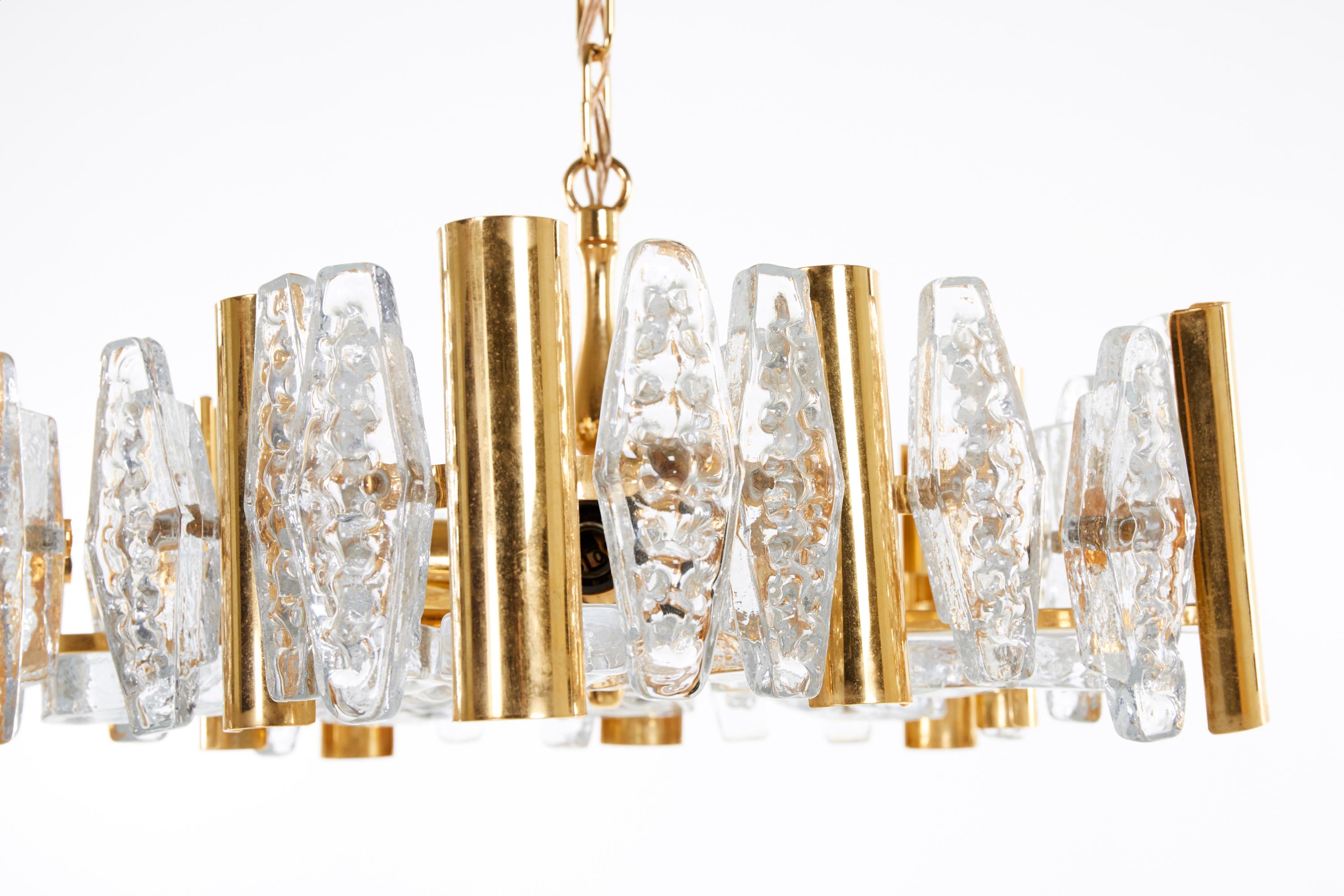 Construcción de latón dorado con cristal prensado, provista de cinco enchufes E14, diseñada en la década de 1960 en Suecia por Carl Fagerlund para Orrefors Glassworks.
    