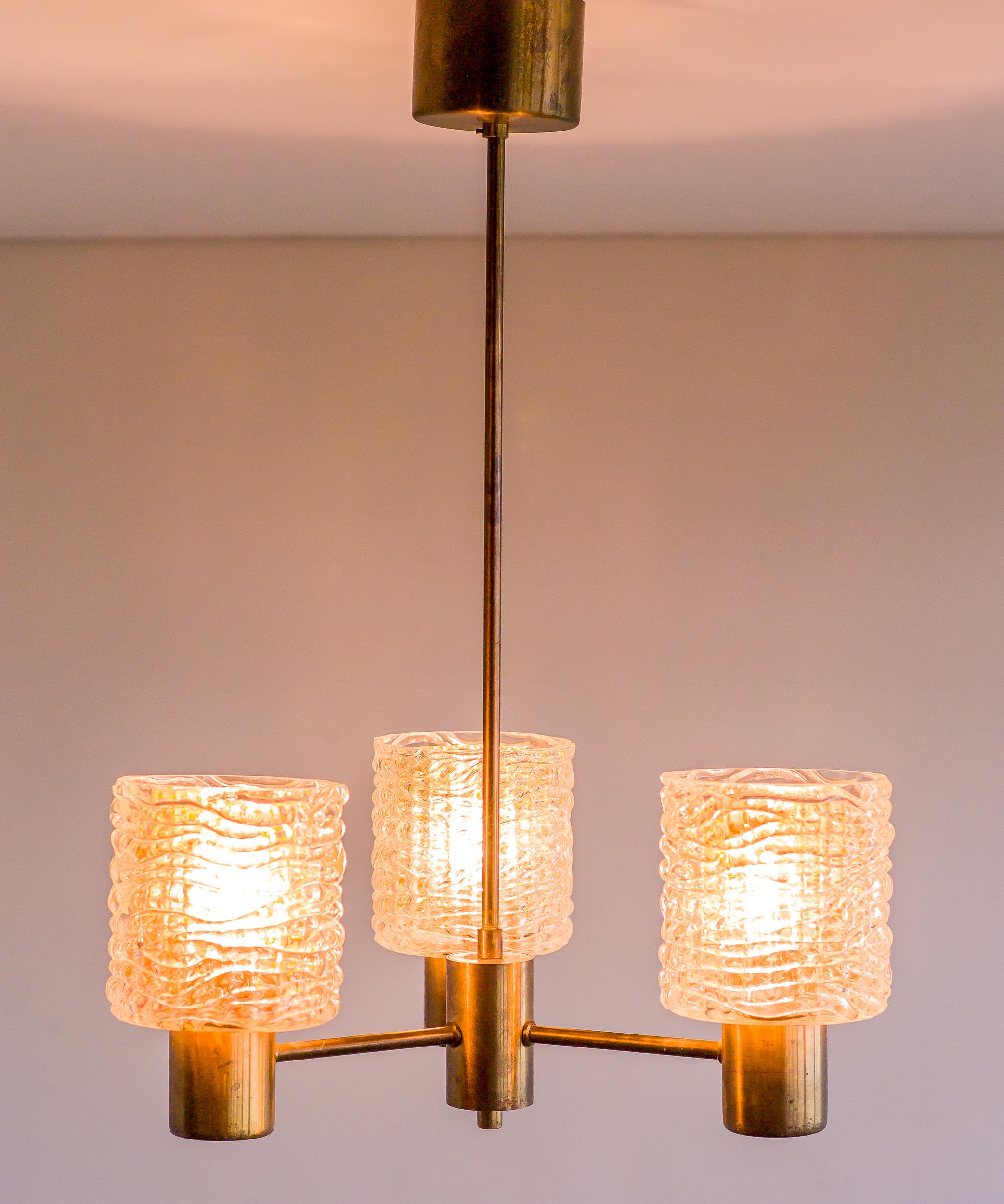 Brass chandelier with crystal shades over amber glass interior shades designed by Carl Fagerlund for Orrefors, Sweden, circa 1960s.

Many museums, churches and headquarters of large companies house the work of Scandinavian modernist lighting