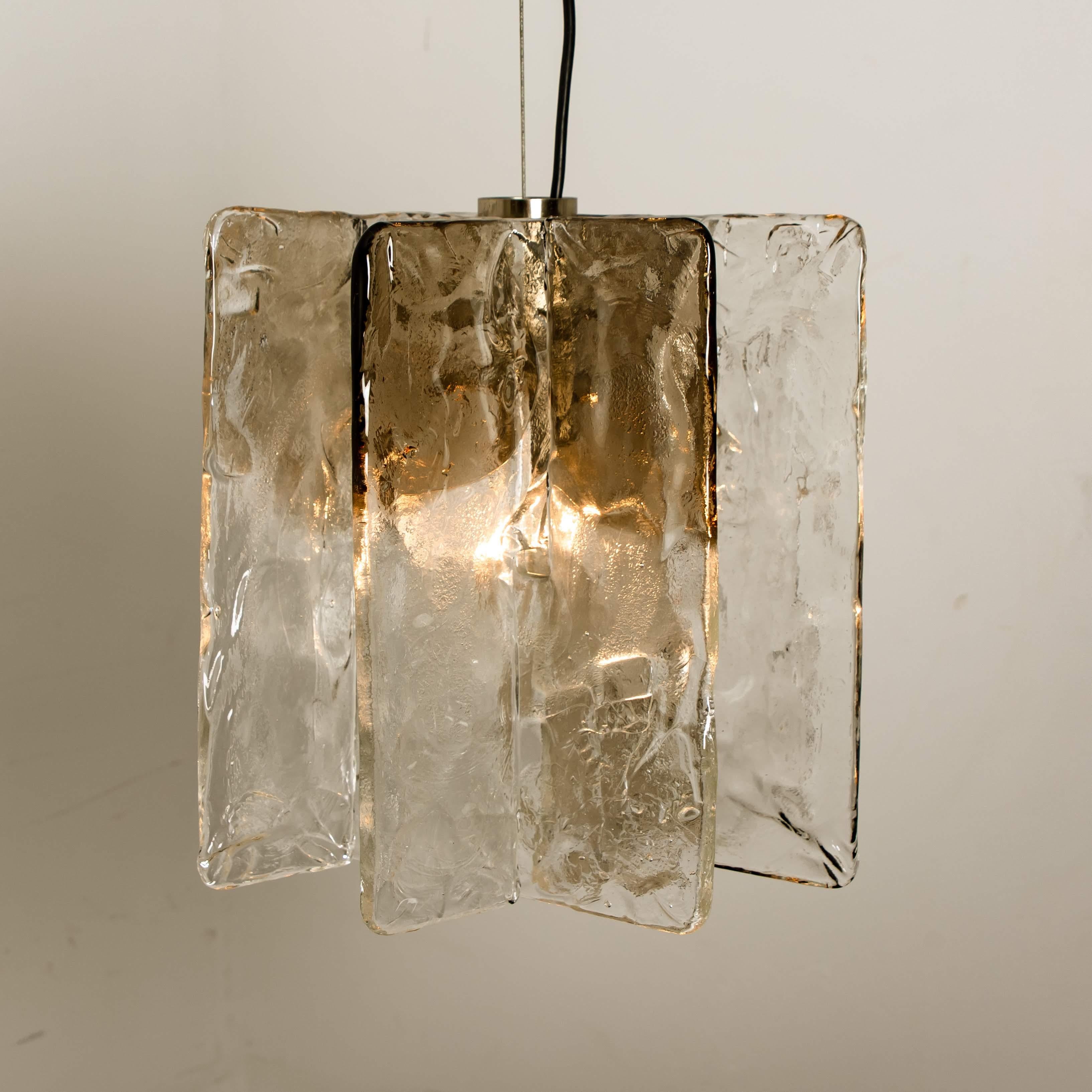 Kronleuchter von Carlo Nason für Mazzega, 1970er Jahre. Die Leuchte besteht aus vier 0,5 cm dicken Glasplatten aus klarem und geräuchertem Glas, die auf einem vernickelten Sockel montiert sind. Sie hat eine E27-Fassung (max. 80 Watt).

Schwere