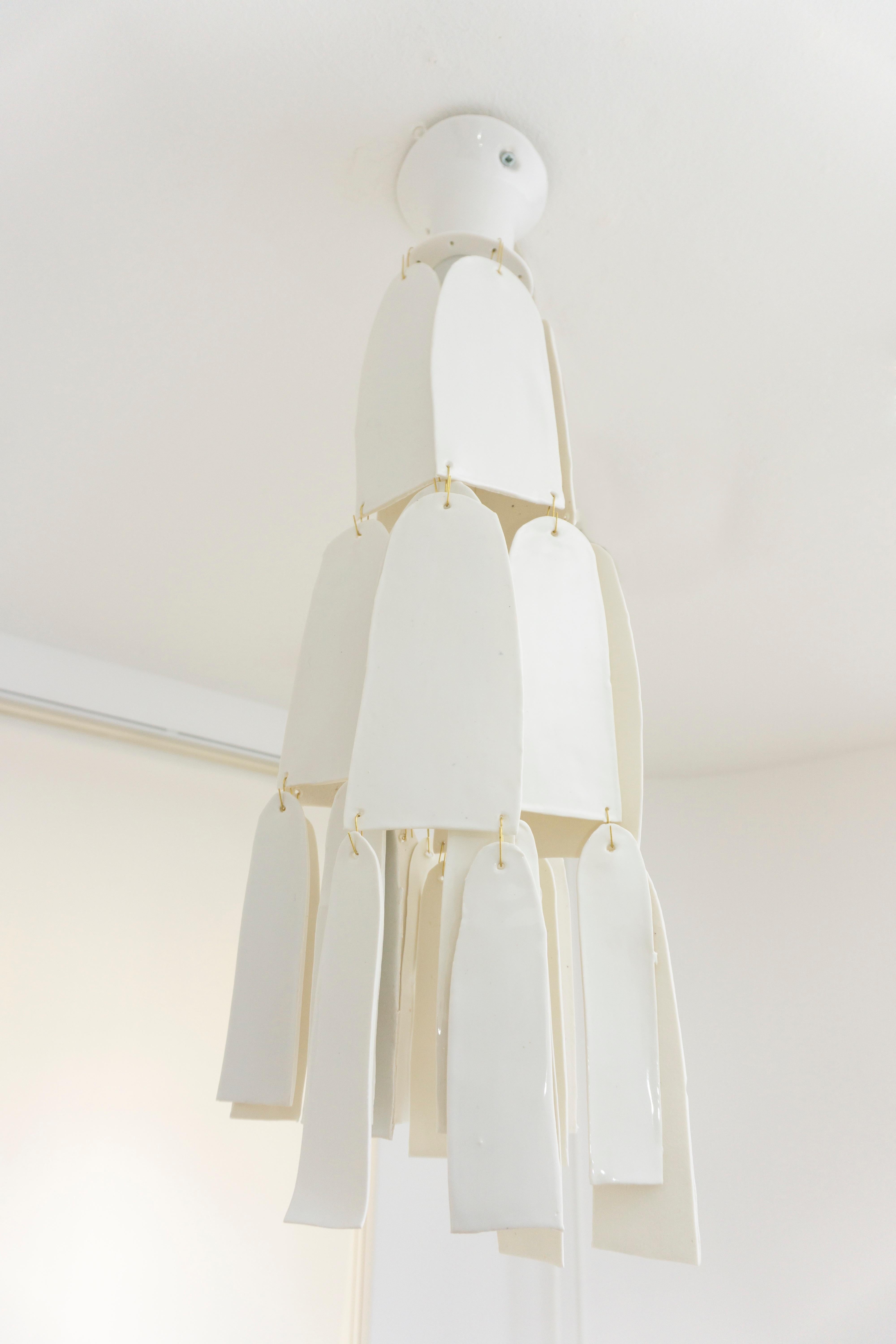 Unique and delicate chandelier, made of porcelain with a glossy white glaze. Catches the light playfully with its pending petals.