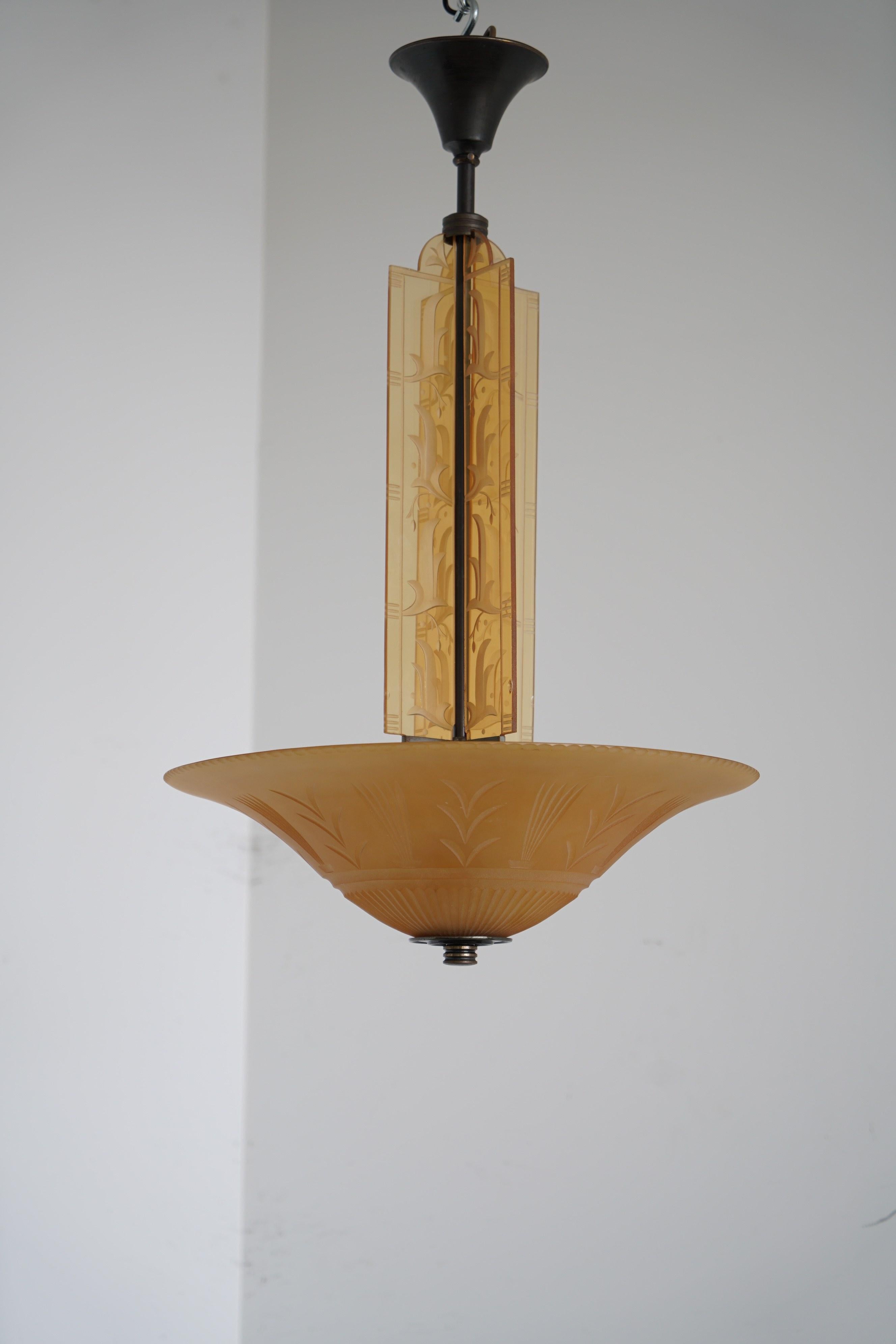 Rare chandelier by Edward Hald, Orrefors, 1930s. Clear Rio brown glass plate and four glass pillars in light-brown glass with engraved and blasted geometric décor. Height 85, diameter 51cm. Rewiring available upon request. Literature Brilliance of