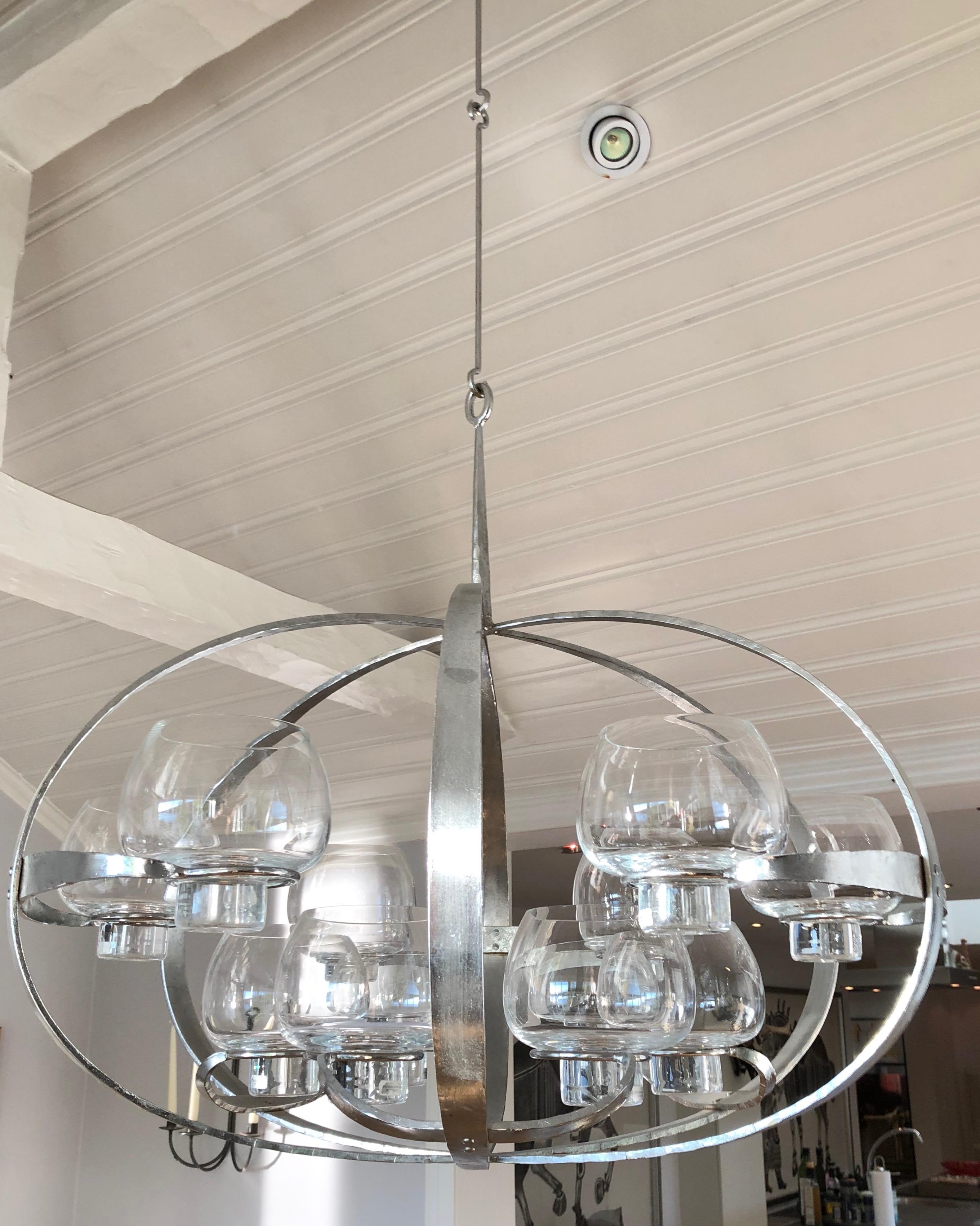 A Swedish chandelier with 12 glass holders for candles. A very unusual design made by Erik Höglund. Iron and glass.