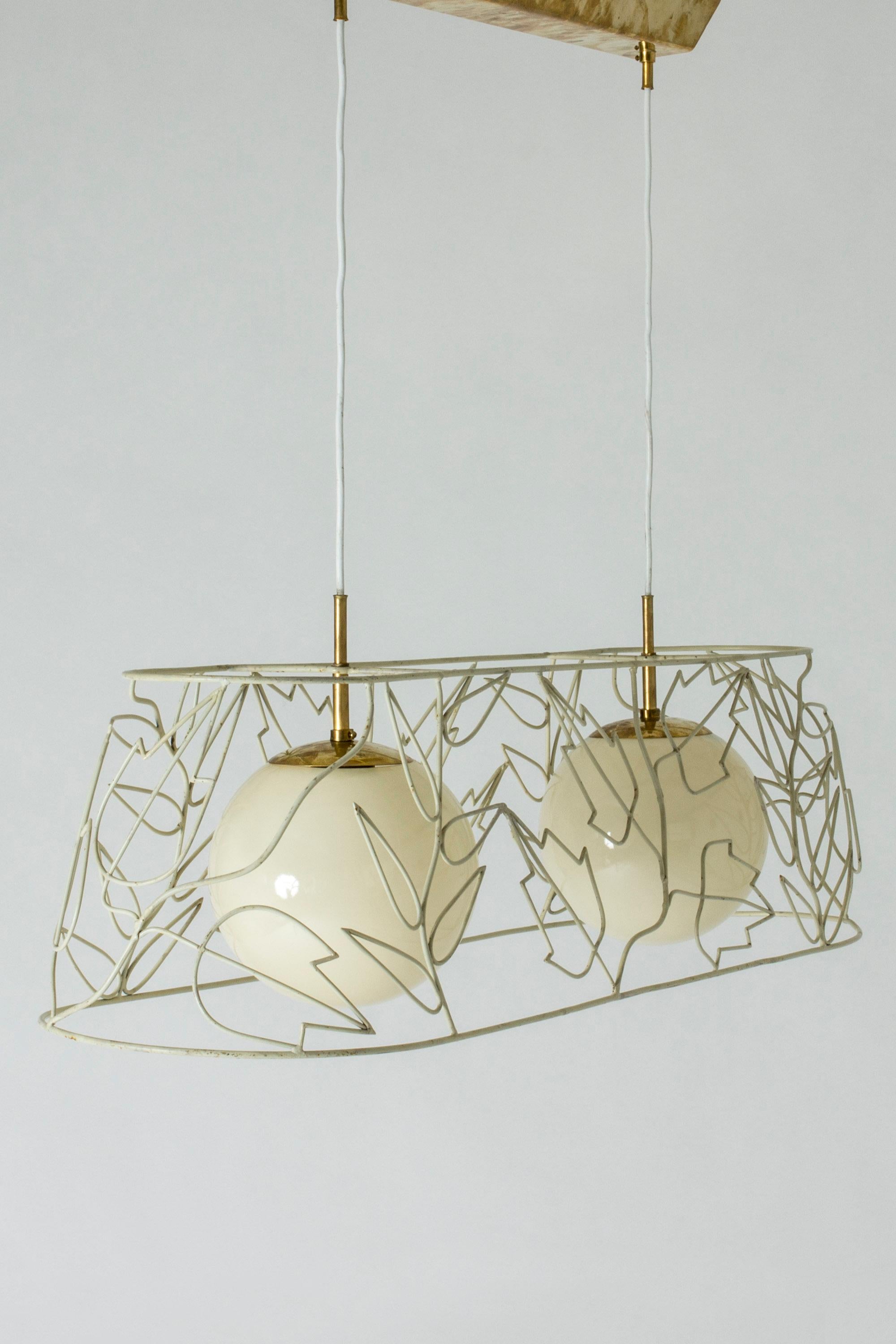 Amazing chandelier by Hans Bergström, with an elongated, airy metal frame of lacquered metal. Two globe shaped light shades inside that let out a soft glow. Beautiful pattern of flowers and leaves. Subtle brass details.
