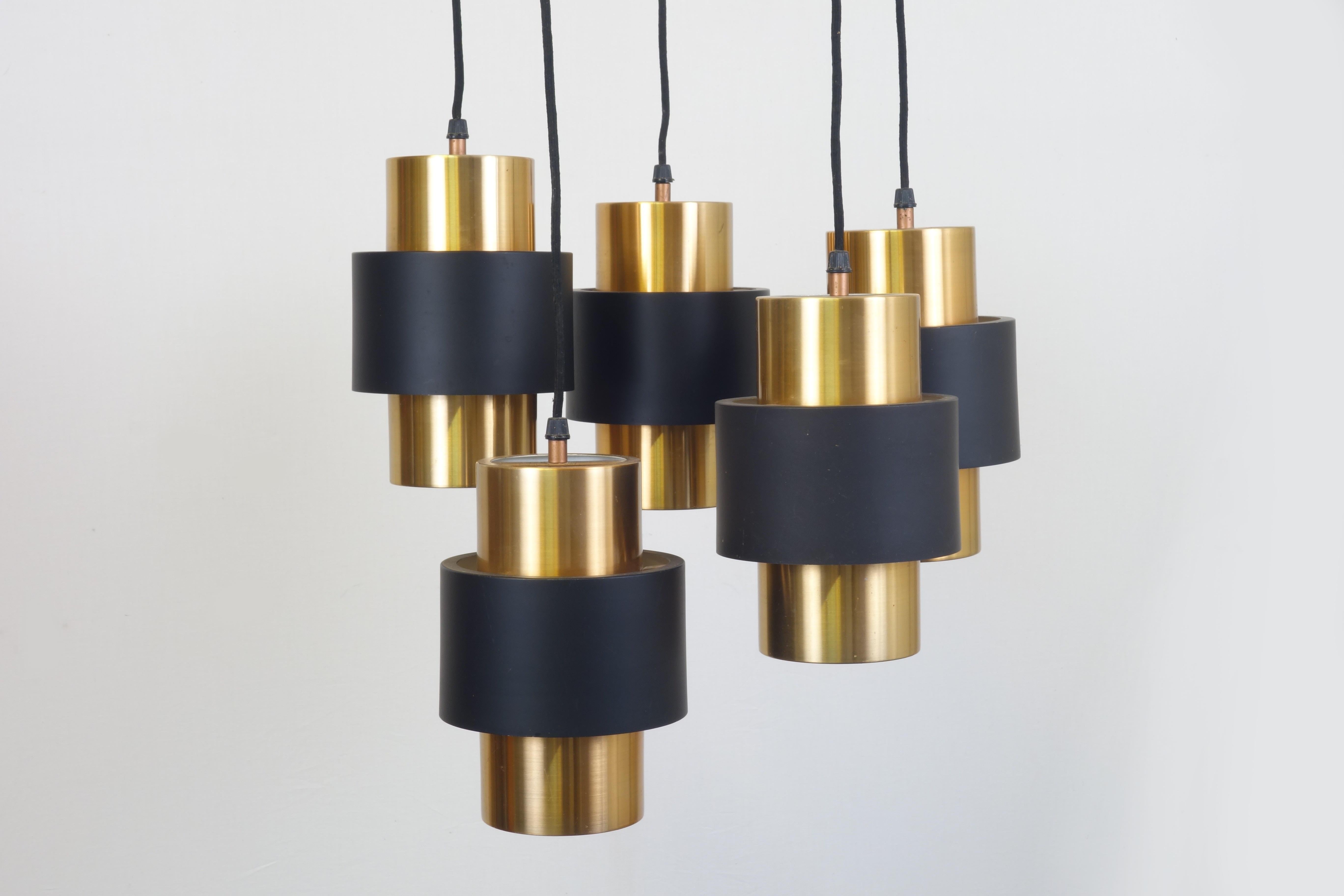 Elegant chandelier designed by Jo Hammerborg, Denmark, 1970s. Central hanger assembly carries 4-light fixtures of brushed copper and blackened metal containing each one bulb. The height of each fixture of this stunning object can be varied