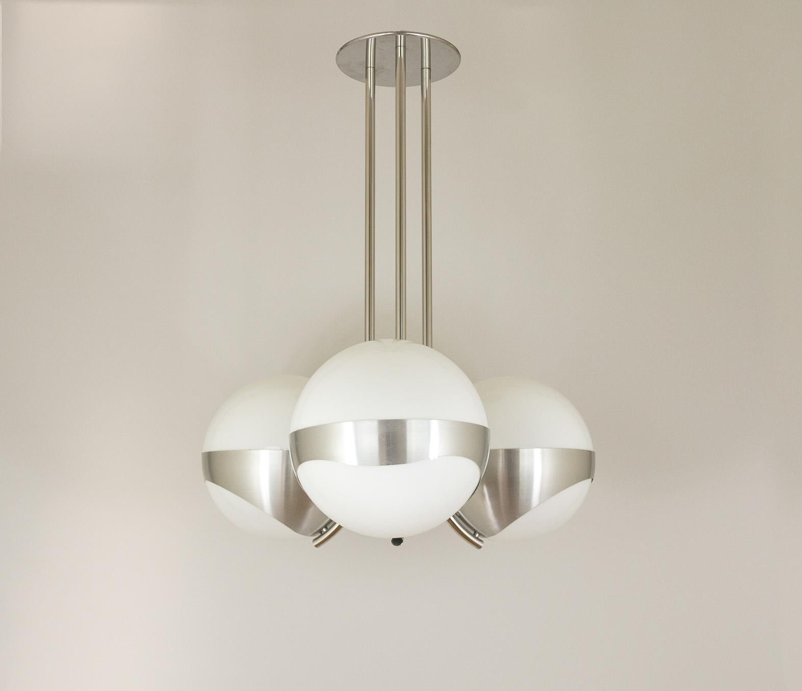 Striking chandelier with three large white glass globes nestled in an anodized metal frame. Designed and manufactured in Italy by Lamperti in the 1970s.

The condition of the lamp is good, with only some minor scratches on the frame.


