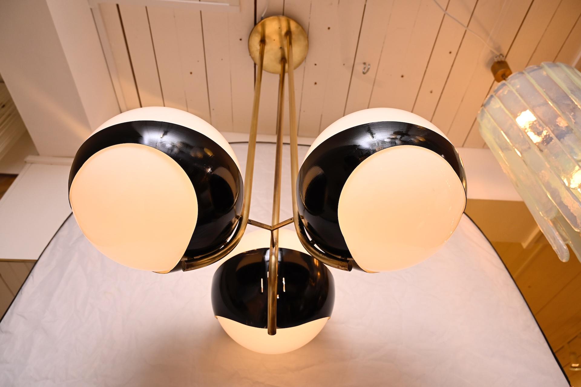 The rarer form of this light in brass and black lacquer frame with three large white glass balls.

Light has been re-wired for Europe and the US.
