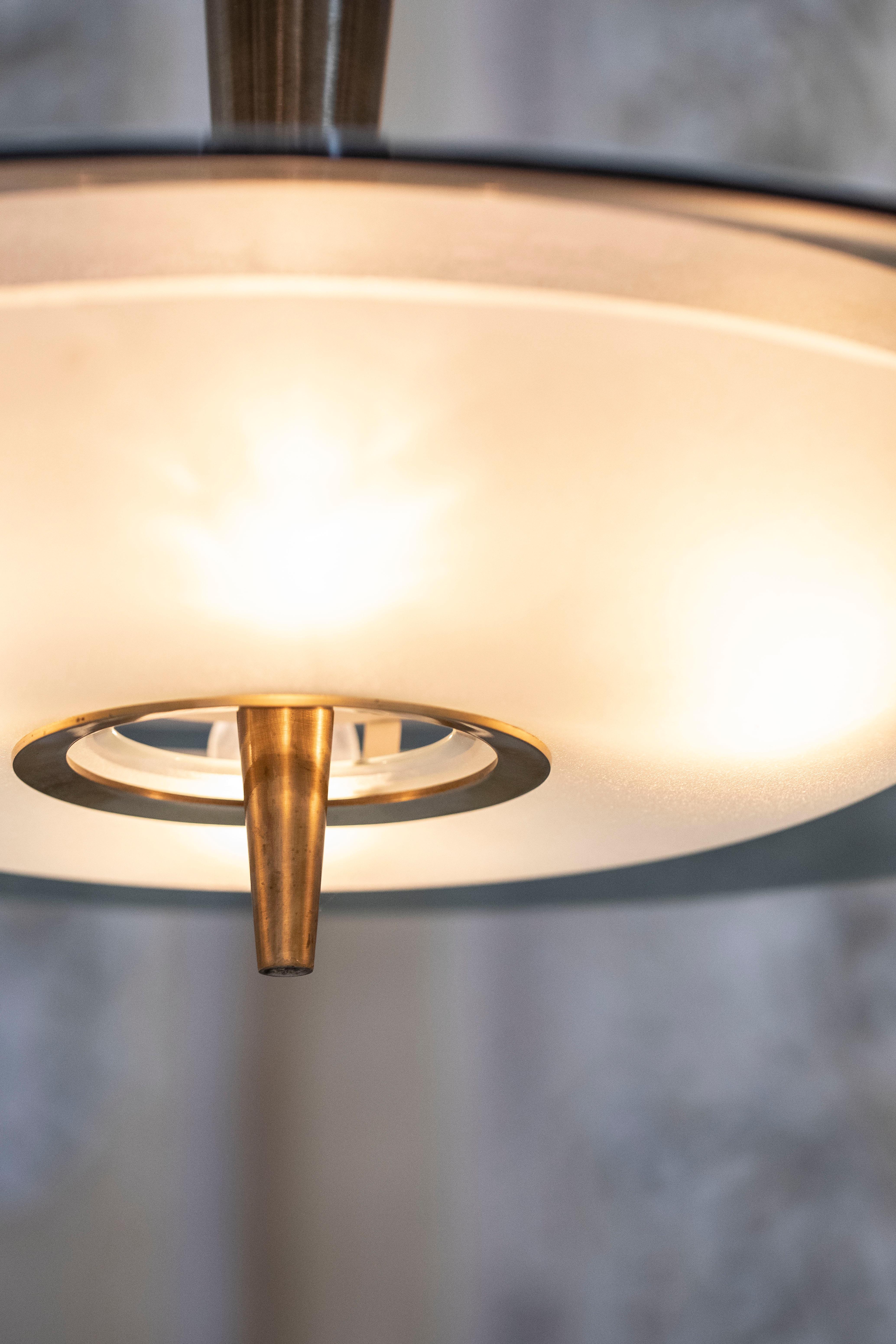 A stunning modernist chandelier by Max Ingrand for Fontana Arte. A beautiful, large and curved glass shade arcs over a convex satinated glass bowl. A particular tapering conical stem with pointed finial in polished brass keeps the two part together.