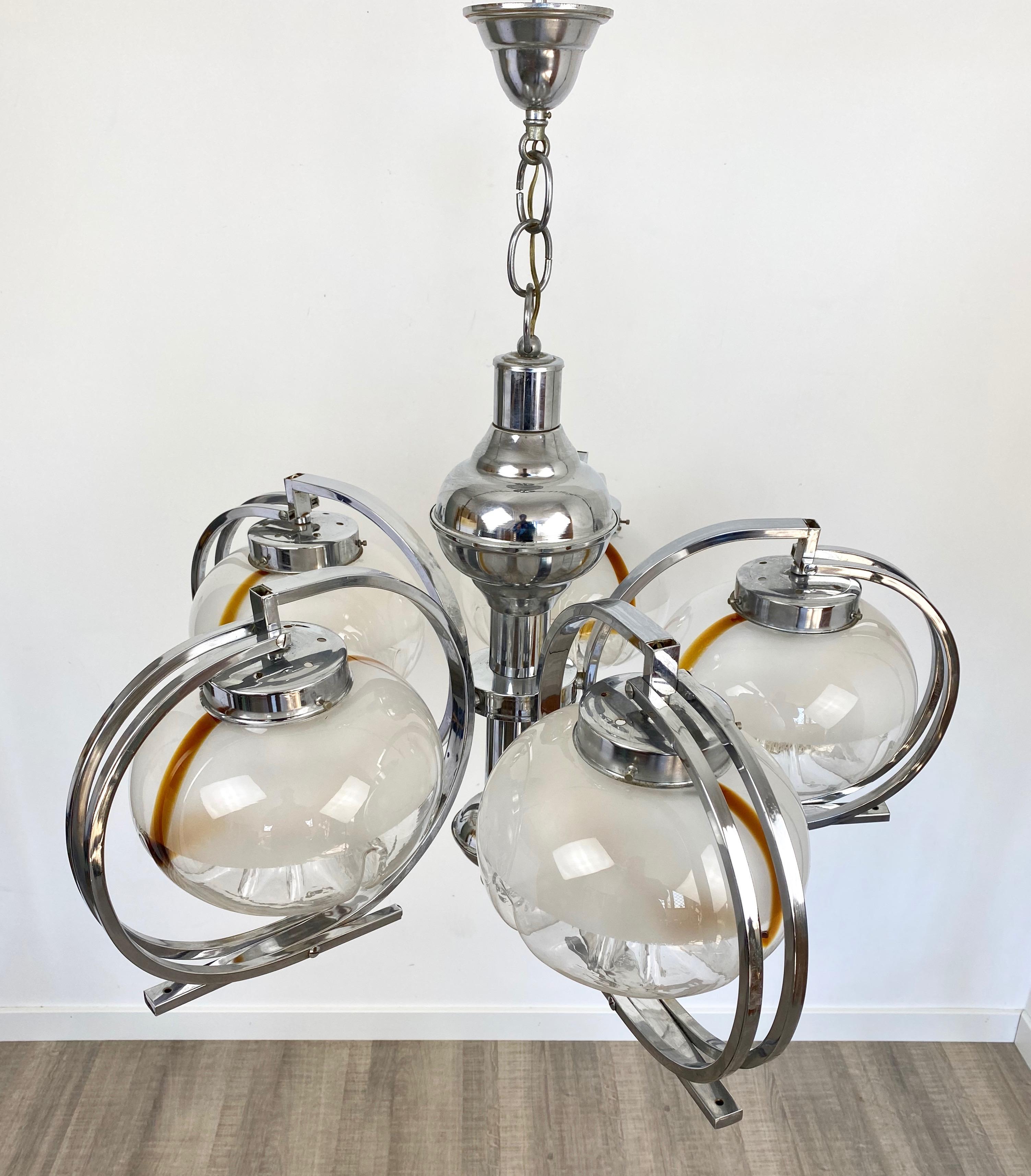 Chandelier pendant in a chrome structure and five Murano glass balls that embellish the light bulbs. Made by the Italian Mazzega, circa 1970.