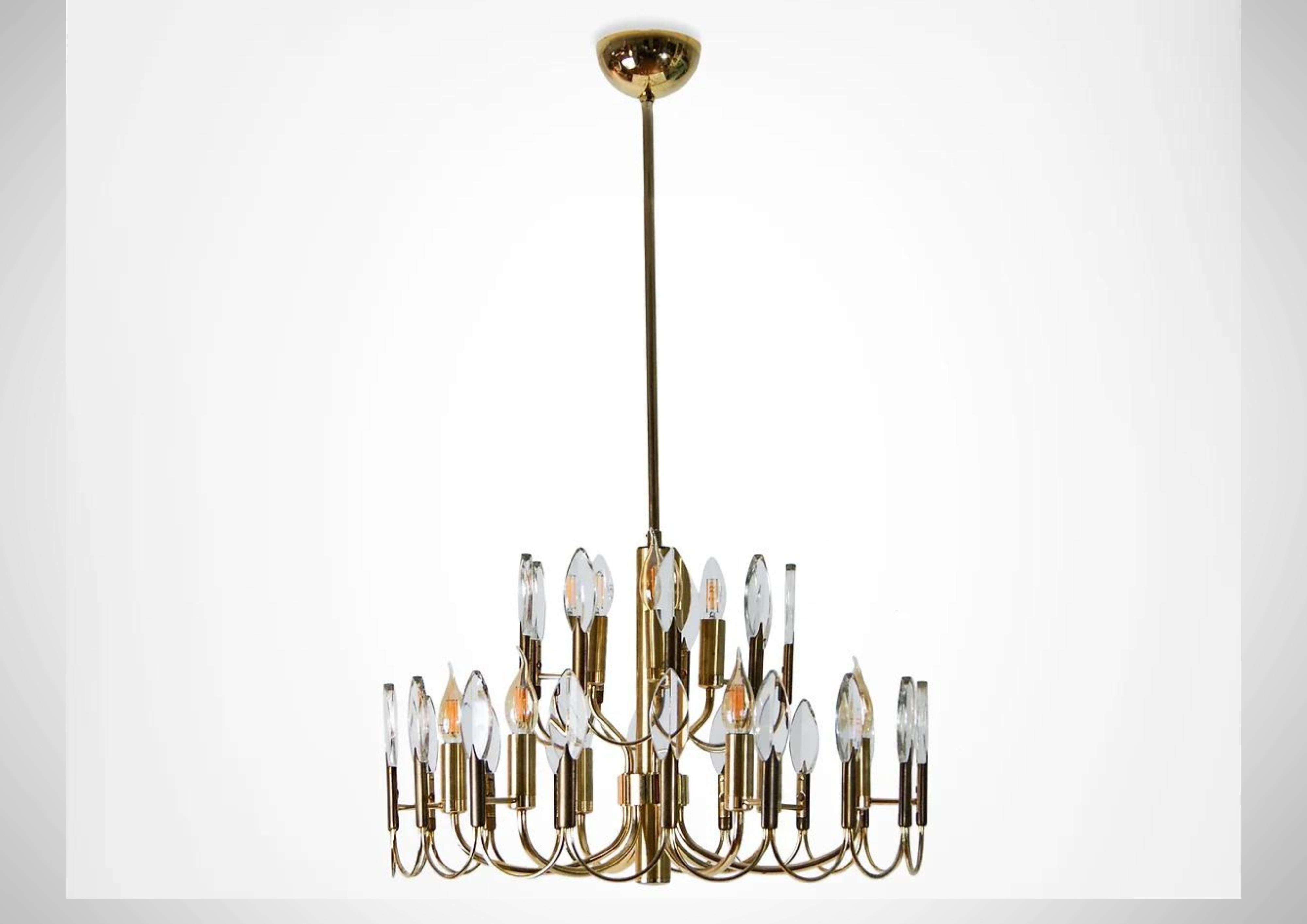 Mid Century large ceiling chandelier by Oscar Torlasco for Stilkronen.
Monumental 2 tiered brass and crystal ceiling light with 9 light points.
Consists of 28 cut glass crystal tips that attach unto a skeletal brass frame.

Uses 9 E14 (Edison small