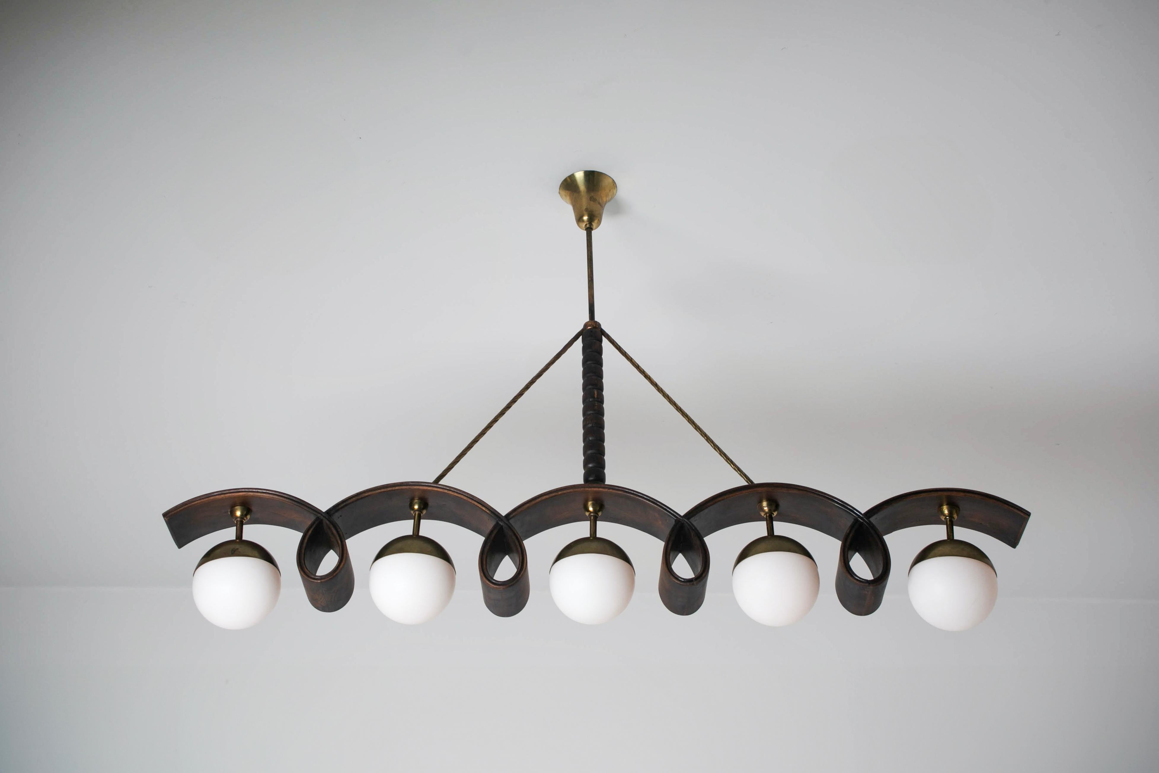Chandelier by Osvaldo Borsani. Designed and manufactured in Italy, circa the 1940s. Beautiful linear bentwood chandelier consisting of a dark stained wood ribbon construction, paired with five opaline glass diffusers. A twisted brass stem finishes