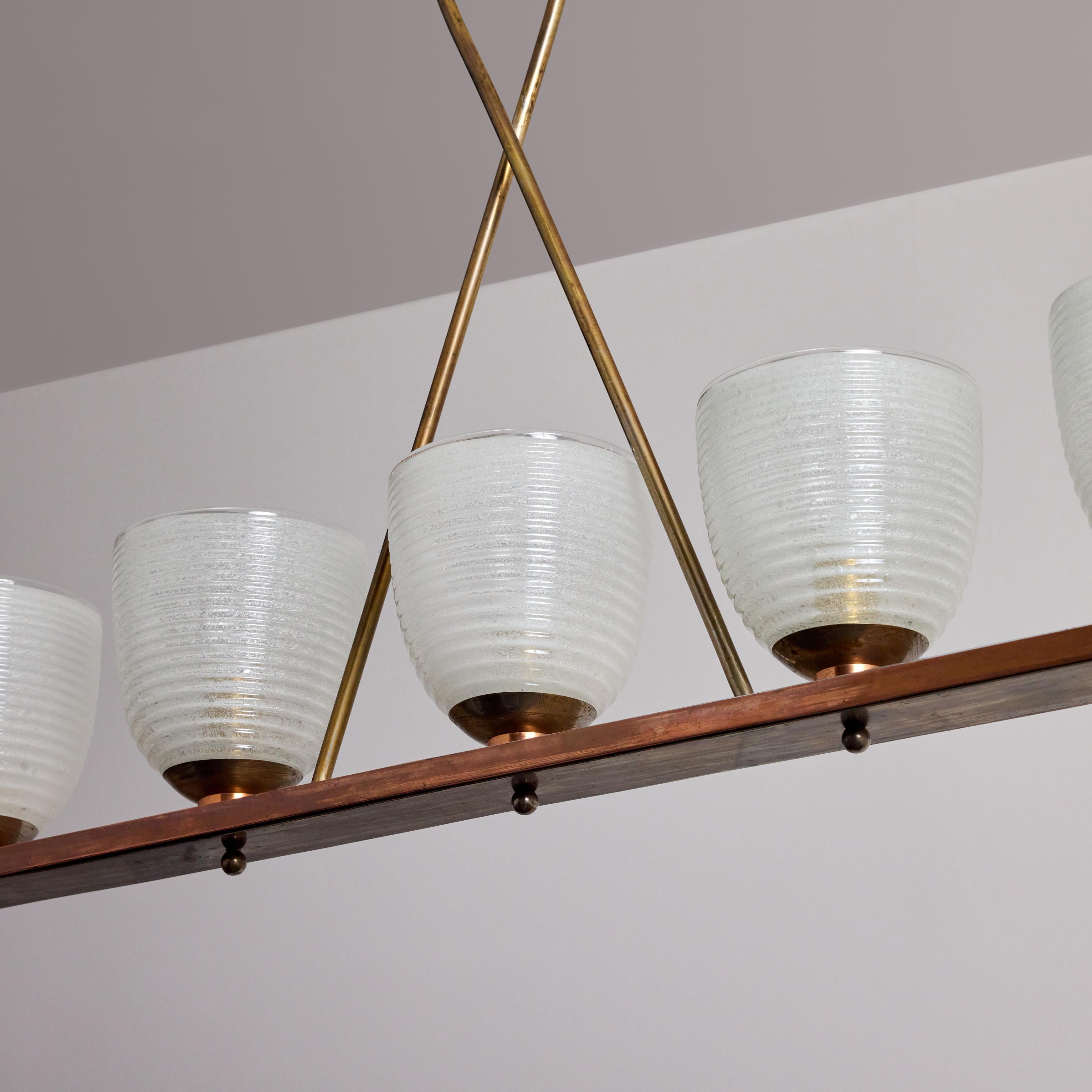 Chandelier by Seguso. Designed and manufactured in Italy, circa 1940's. Hand blown Pelgoso glass rest on a beautifully aged brass linear constrcution. Original canopy, custom brass backplate. Wired for U.S. standards. We recommend one E27 60w