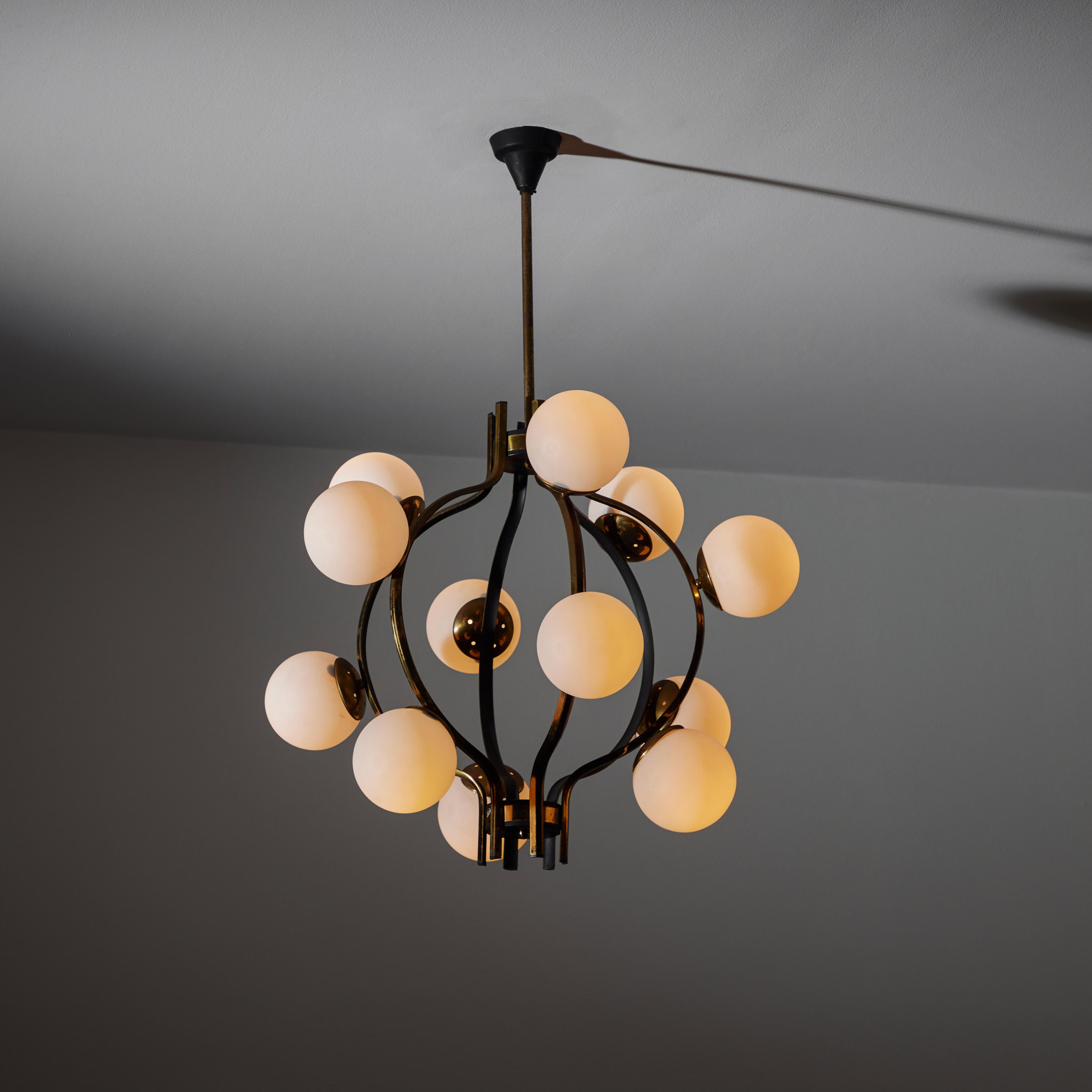 Chandelier by Stilnovo. Manufactured in Italy, circa the 1950s. Aged polished brass and painted black hardware throughout. Rewired for U.S. standards. Original canopy, custom brass ceiling plate. Eleven E14 20W Max bulbs recommend. Bulbs are