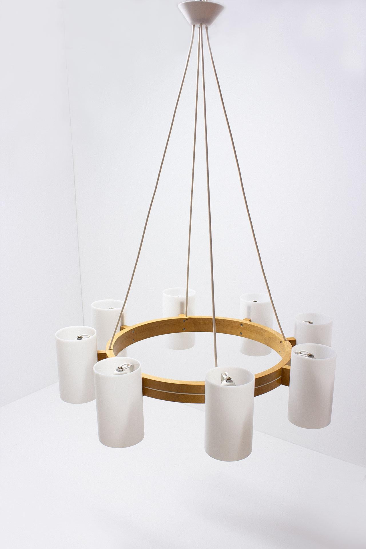 Large chandelier designed by Uno & Östen Kristiansson for their own company Luxus in Sweden during the 1960s. Solid oak structure with large acrylic diffusers. Adjustable height according to preference. 8 lampshades. Height of the shades: 20cm.
Very