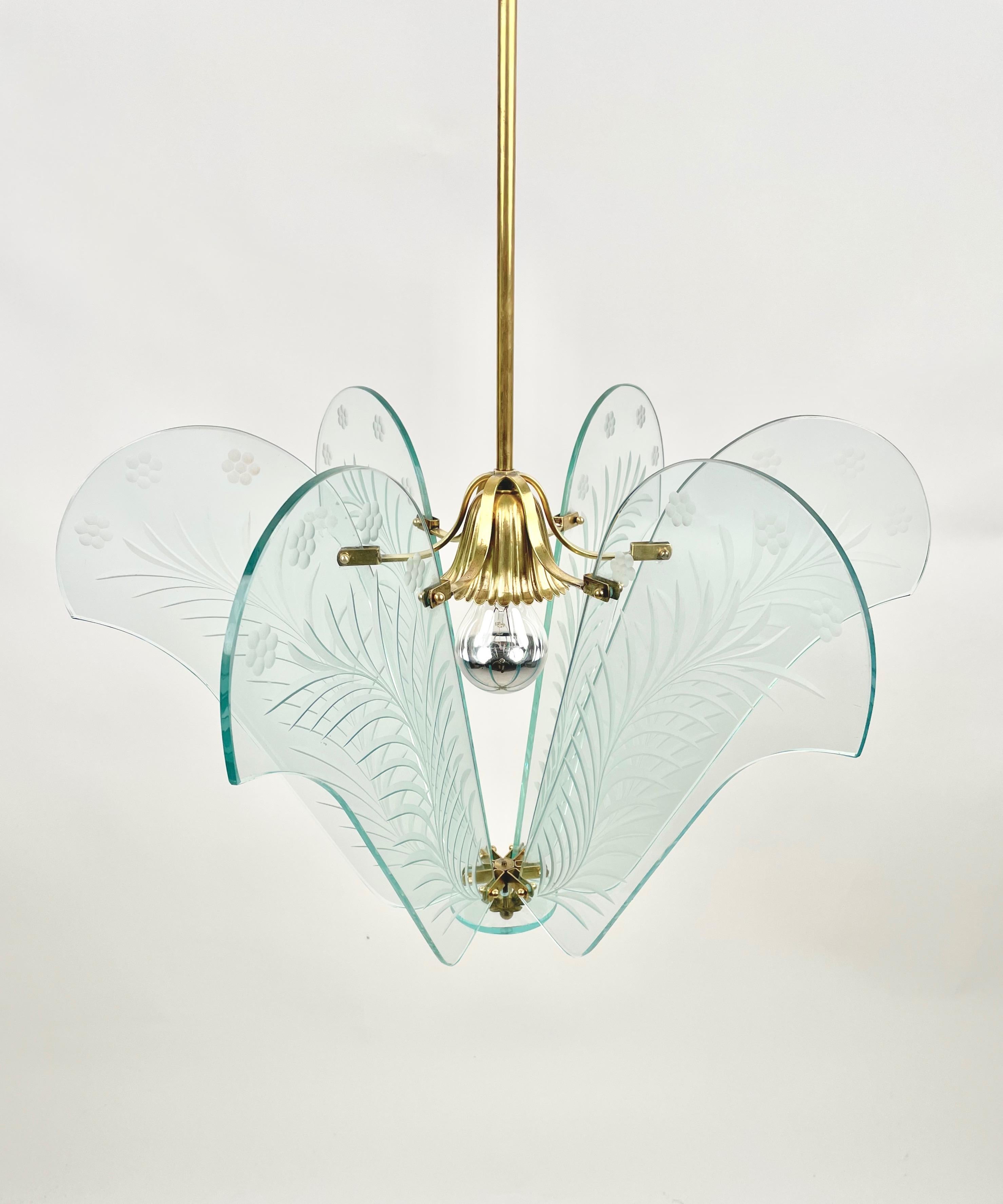 Chandelier pendant in glass with carved floral details and brass in the style of Fontana Arte. Made in Italy in the 1950s. 

Measures: Height with pole: 115 cm.
Height without pole: 32 cm.
Diameter: 53 cm.