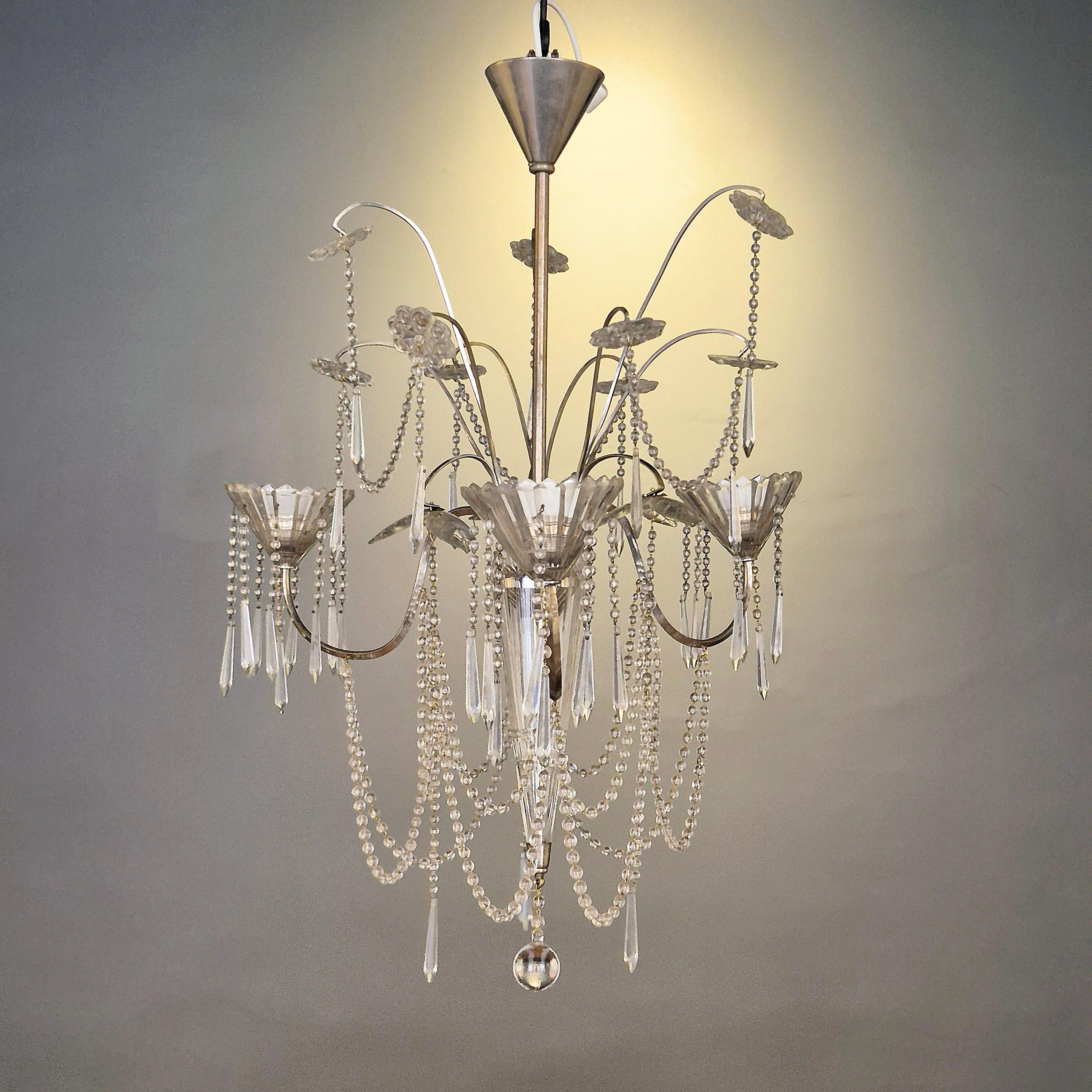 A beautiful rare chandelier with crystal details and silverplated metal base. Swedish neoclassicism, 1920s. In the manner of court jeweller CG Hallberg.

A true timeless gem. Re-wired by previous owner, for swedish use. We recommend to re-wire