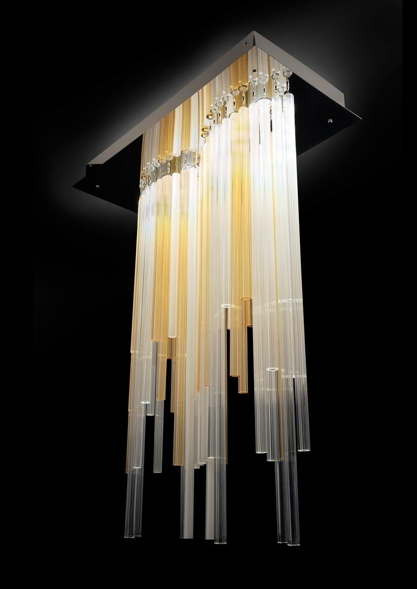 This beautiful big-size chandelier by Venini, is a luminous lighting system that employs the “Canna Rigadin” in handmade blown Murano glass. The canes, different in length, emphasize the light diffusion trough the texture of the external surface.