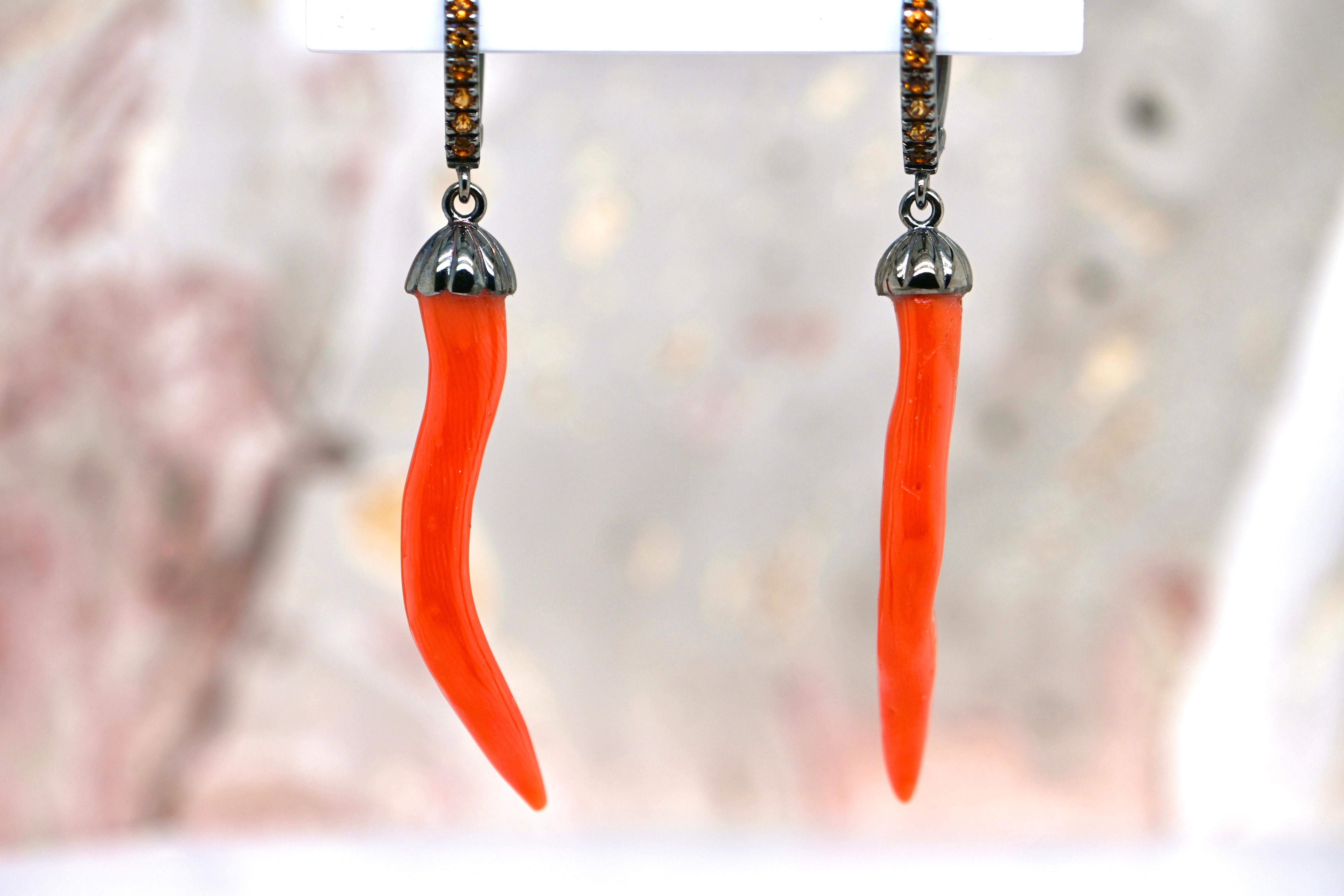 Coral, a symbol of beauty and femininity for centuries, is carefully selected for its vivid color and natural texture, adding a bewitching touch to these earrings.

Topaz adds a sparkling touch to the composition. Bewitchingly orange, these precious