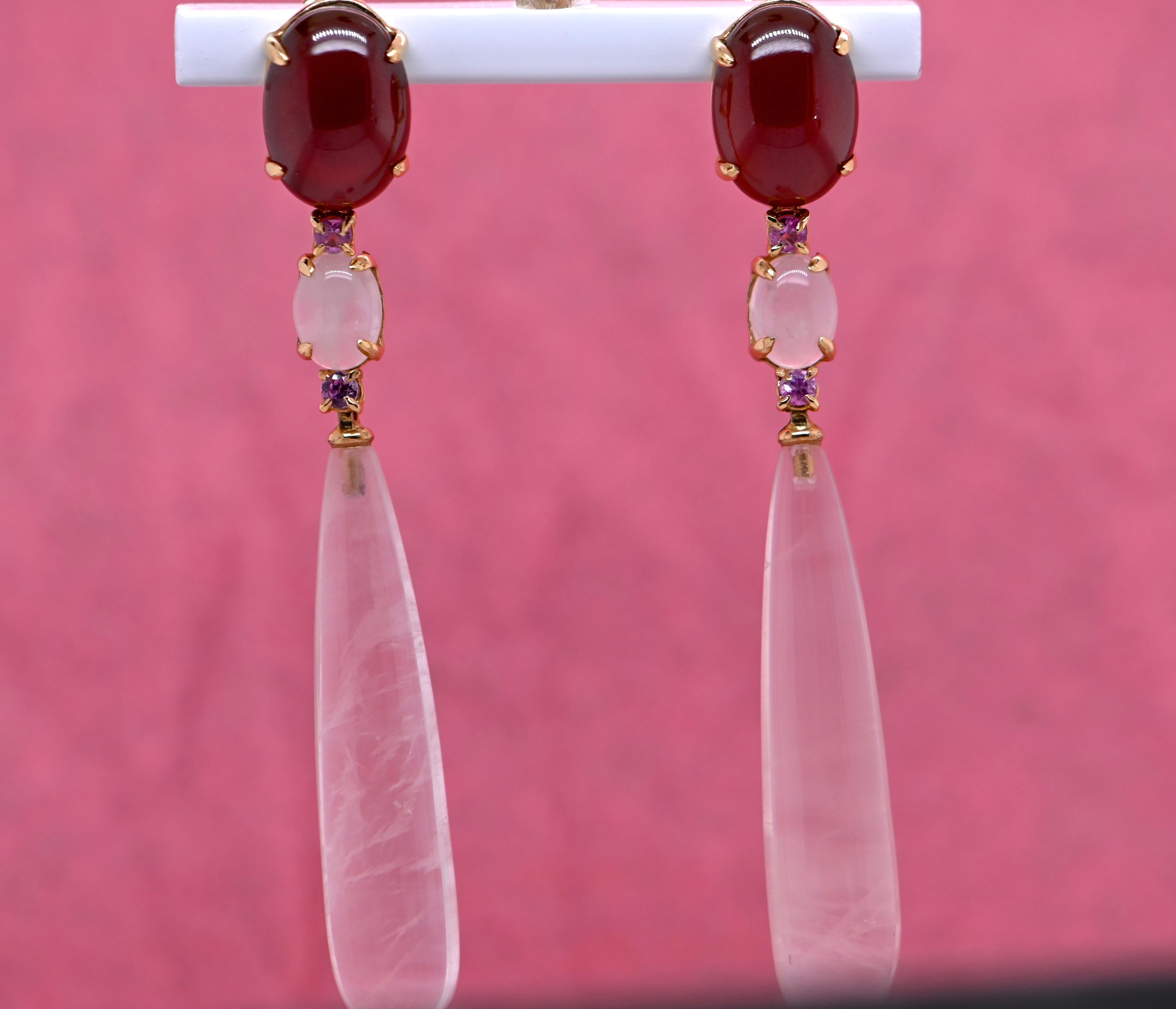 These earrings feature gemstones carefully selected for their natural beauty and mesmerizing brilliance. Two natural garnets, with a rare ruby-red intensity, immediately captivate the eye, adding a touch of passion and mystery to this exceptional