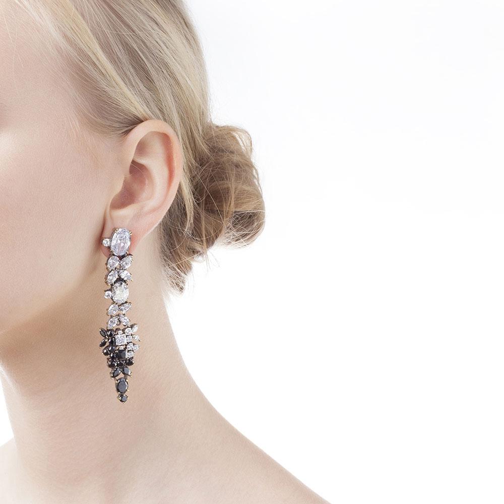 Iosselliani's tribute to the early 80's love for optical! Black and white cubic zirconia in a specular setting for a stunning pair of chandelier earrings. Crafted with a pierce and clip combination, the earrings will add extra grandeur to your