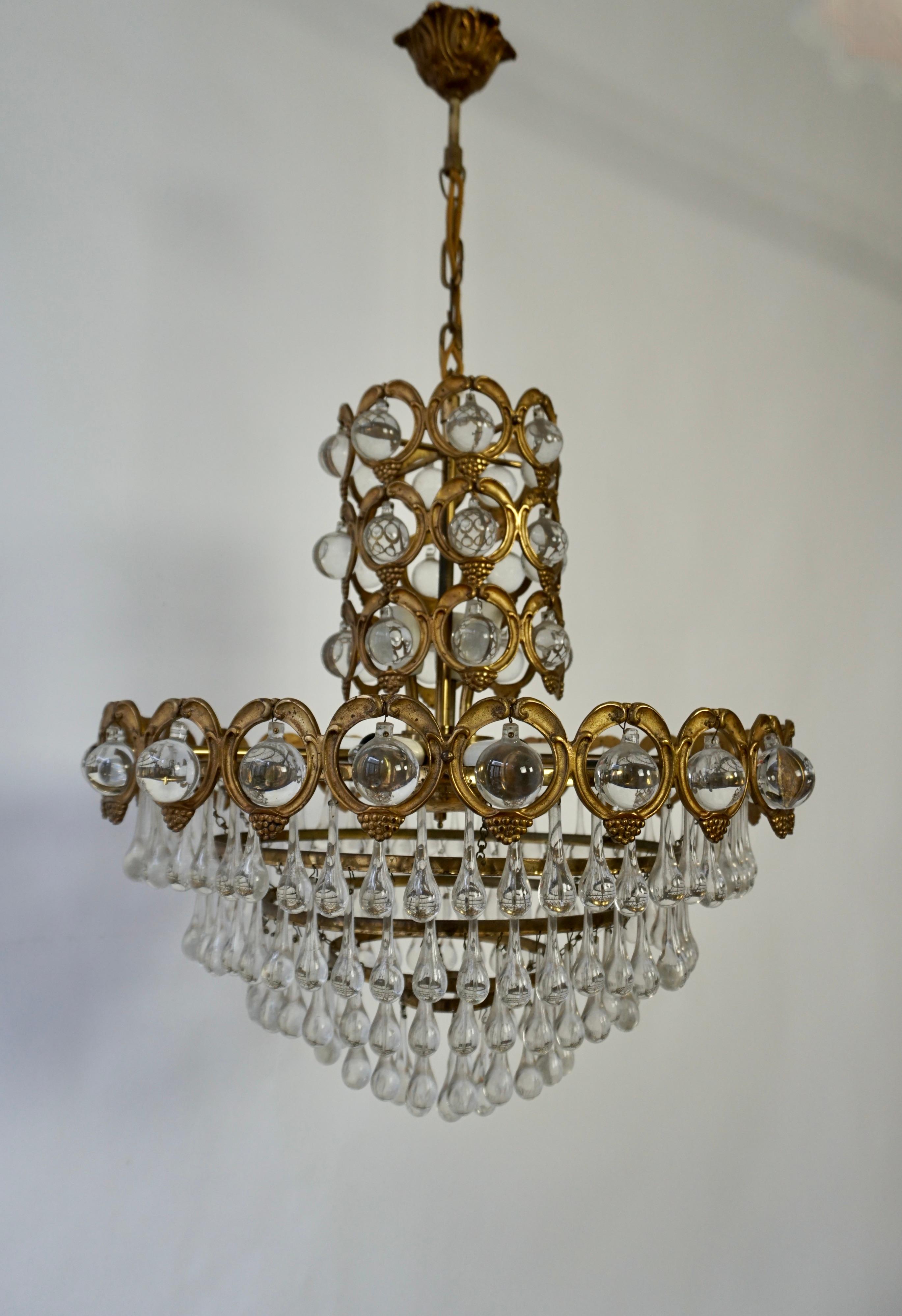 A large Hollywood Regency Italian chandelier in brass and crystal manufactured in the mid-century (1960s and 1970s). 

The lamp has nine sockets for small incandescent lamps with screw base or E14 type LEDs. The height of the body without chain is