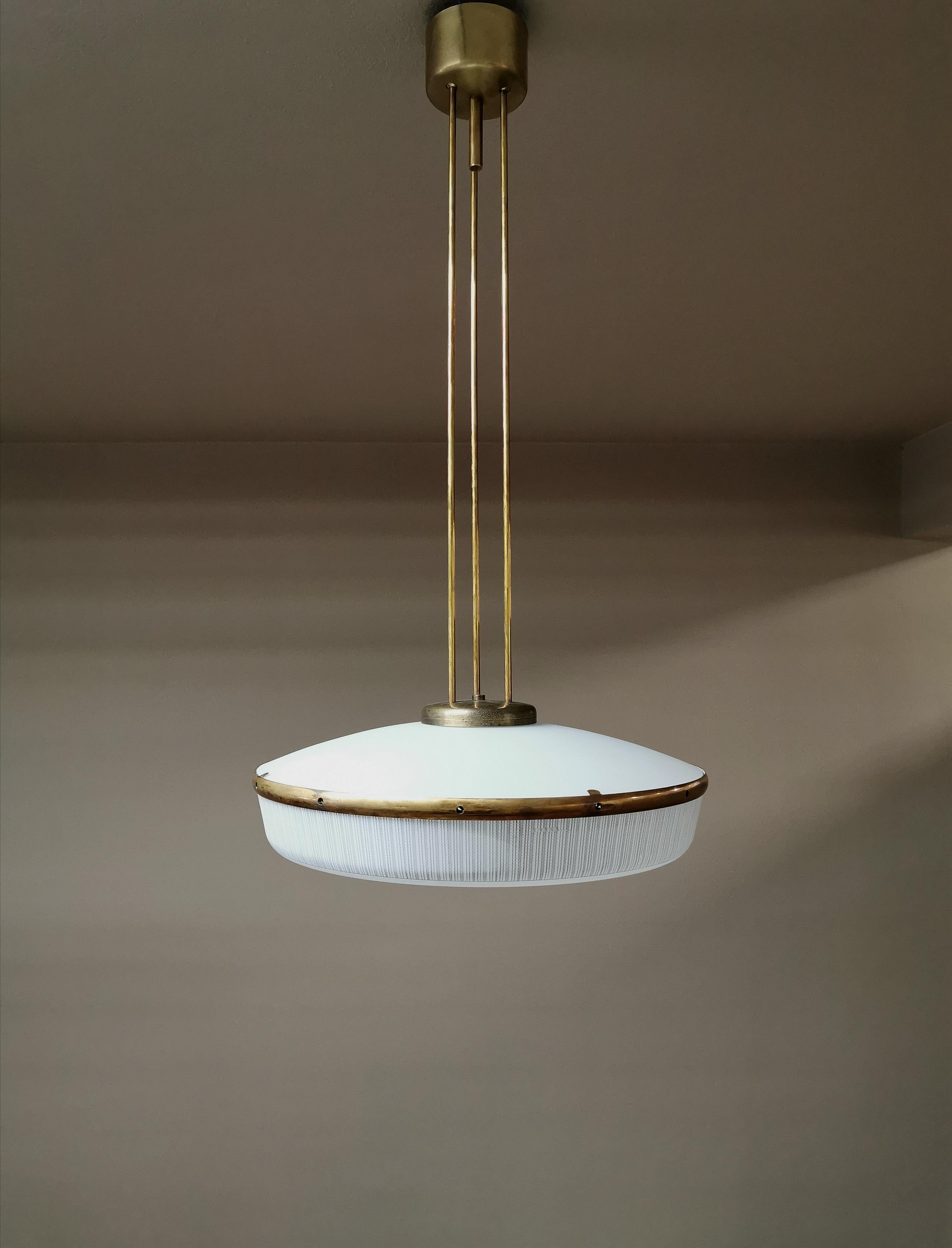 Refined 6-light chandelier in the style of Stilnovo with brass structure with 3 rods that support a white and rough concave glass in the upper part and in the lower part there is a second round glass, all linked by a brass circle. Italian production