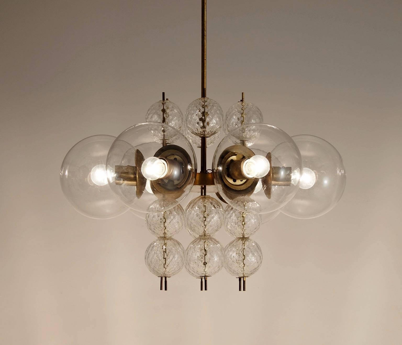 Chandelier, in brass and glass, Europe, 1960s.

Elegant chandelier with brass fixture and structured glass decoration. With six light-points, the chandelier creates a nice warm light. The structured glass and brass emphasize to the great light