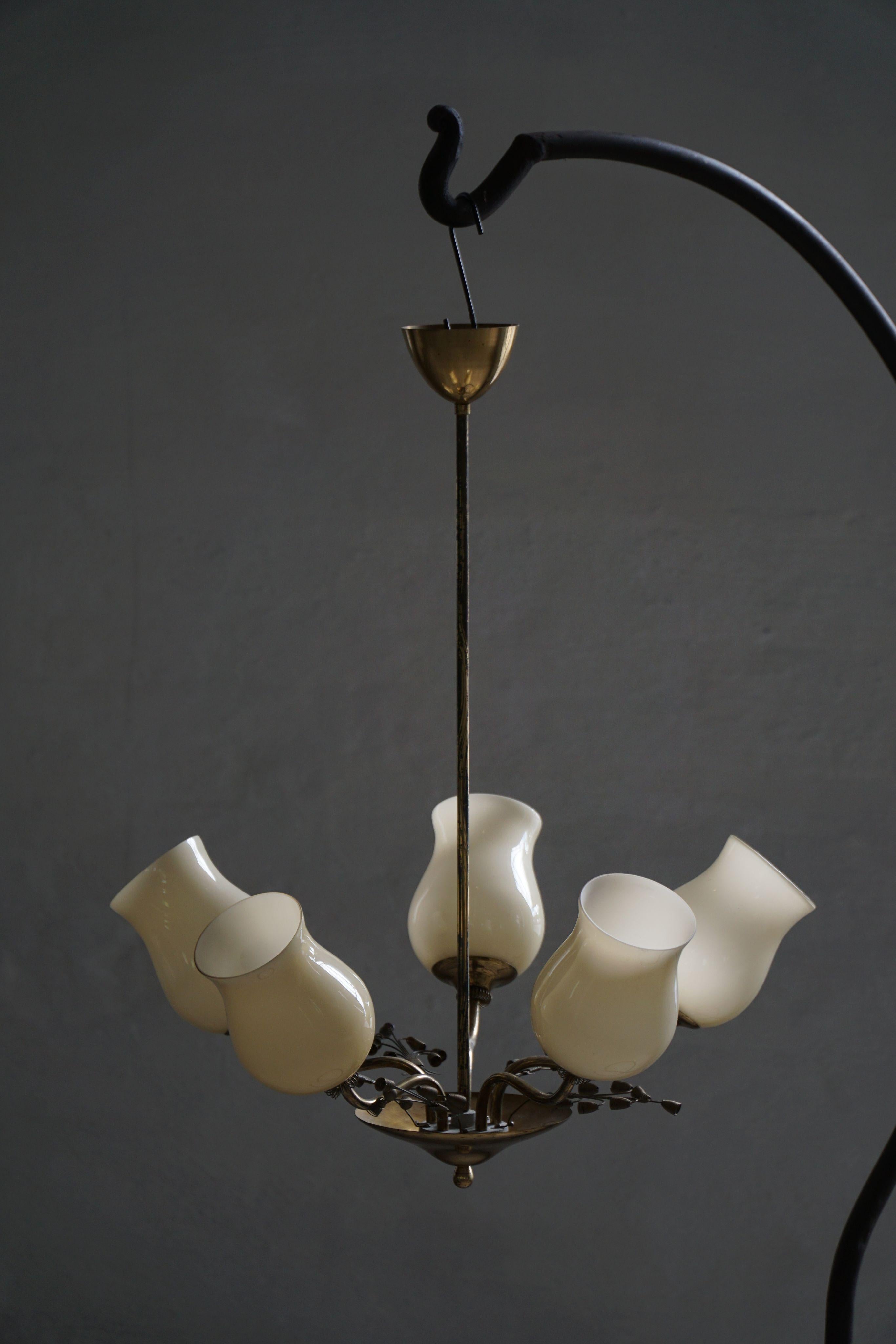 Questo splendido lampadario degli anni '40 di Lisa Johansson-Pape, disegnato per Stockmann, è una graziosa espressione del design finlandese di metà secolo. Realizzato in ottone, presenta sei bracci elegantemente curvi che si irradiano da uno stelo