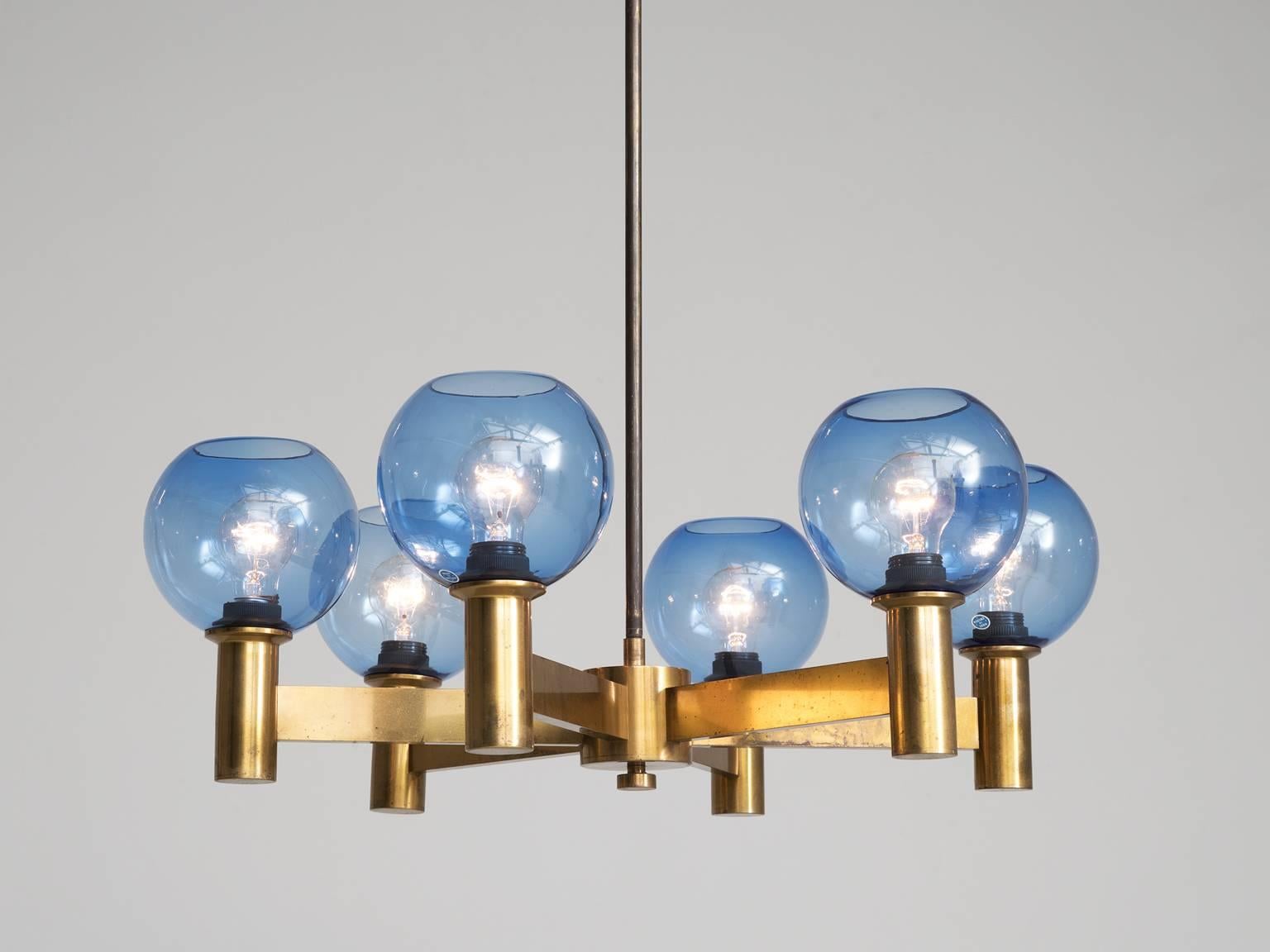 Chandelier, in glass and brass, Sweden, 1960s. 

A chandelier in patinated brass with blue colored glass shades. Divided over six arms this light will create a stunning light partition. The blue glass spheres will create and even more interesting