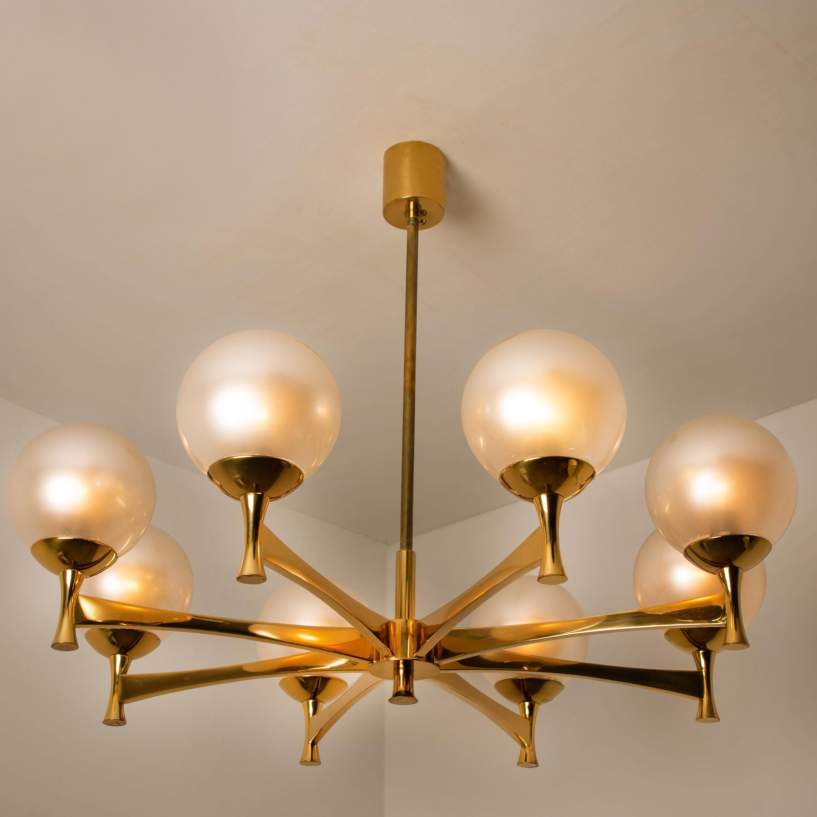Chandelier in brass and opaline glass, Europe, 1960s.

The chandelier consists 8 brass holders with 8 opaline glass spheres. Due the combination of materials these lights will create a beautiful warm and diffuse lights. Designed in the style of