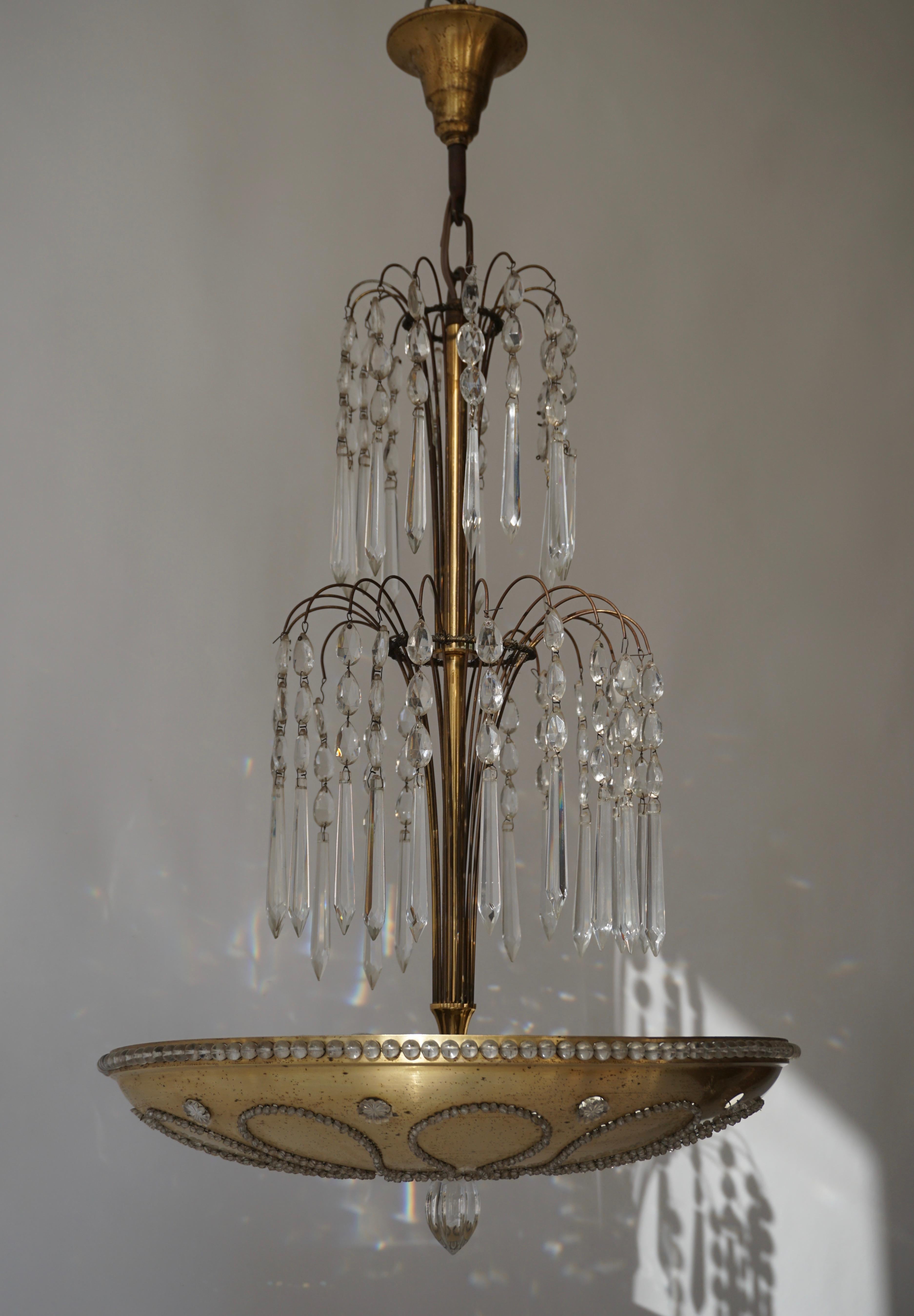 Due lampadari in metallo dorato con decorazioni in cristallo e vetro.
Diametro 46 cm.
Altezza apparecchio 68 cm.
Altezza totale con la catena 85 cm.
Sei lampadine E27.
