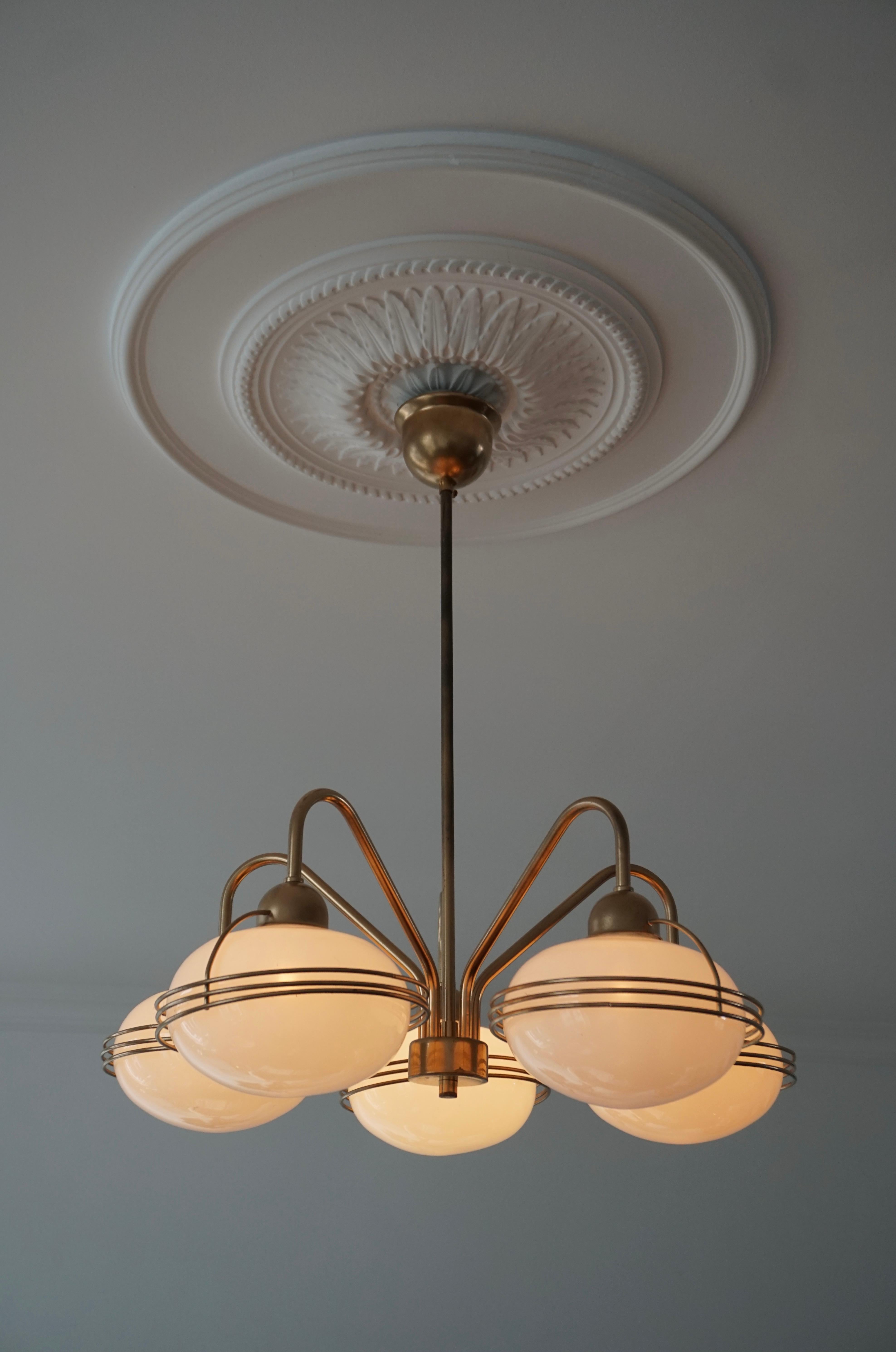 One Italian chandelier in brass with five white blown glass globes.

Measures: Diameter 53 cm
Height 65 cm.
The light requires five single E14 screw fit lightbulbs (40Watt max.) LED compatible.

 