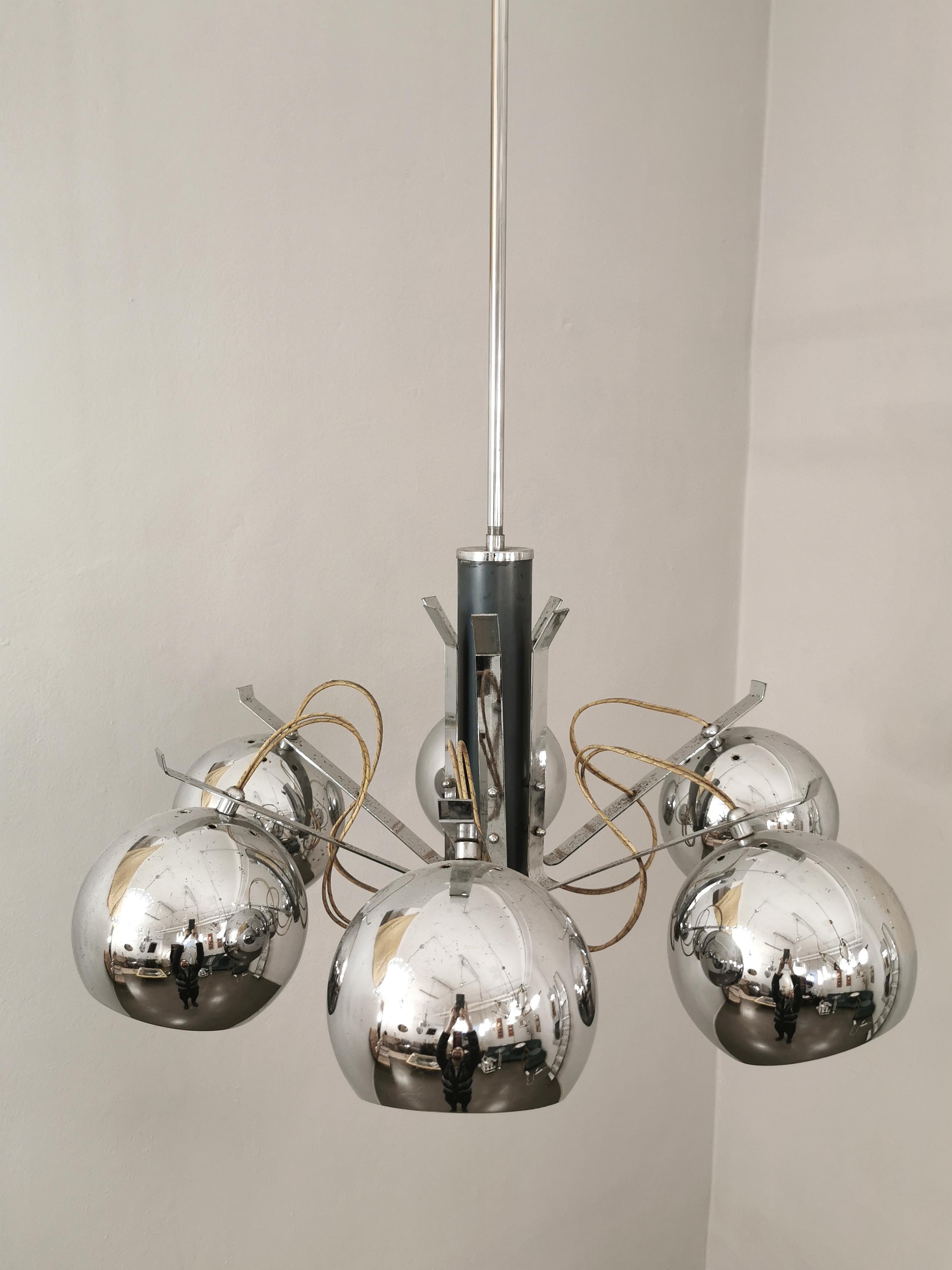Chandelier by the unknown designer with a long stem that supports 6 circular diffusers in chromed metal with 6 E27 lights. Made in Italy in the 70s.