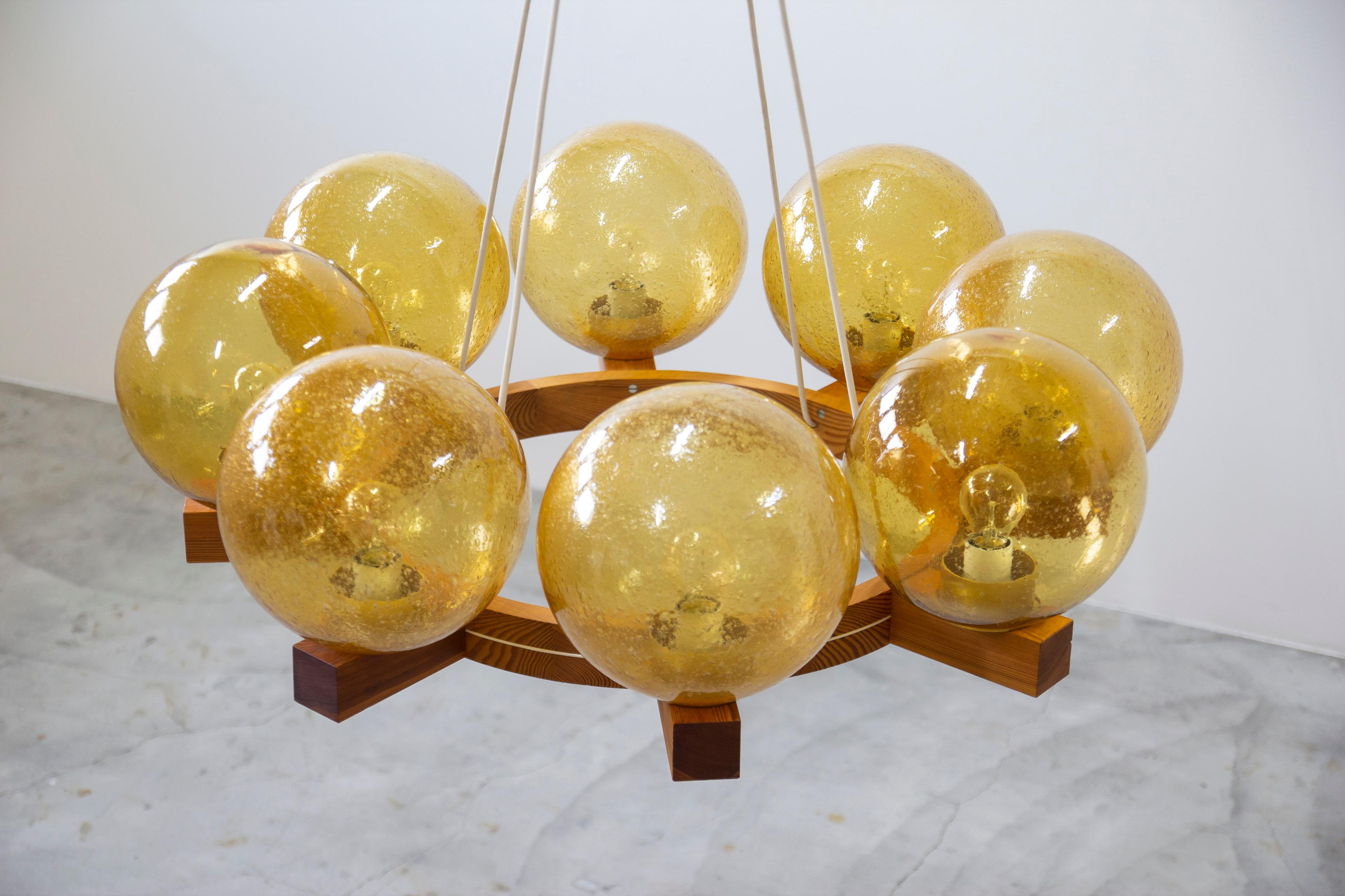 Chandelier designed by Uno & Östen Kristiansson. produced in Sweden by Luxus during the 1960s. Made from solid pine and amber colored bubbly glass shades. Very good vintage condition with light age related wear and patina.



Designer: Uno & Östen