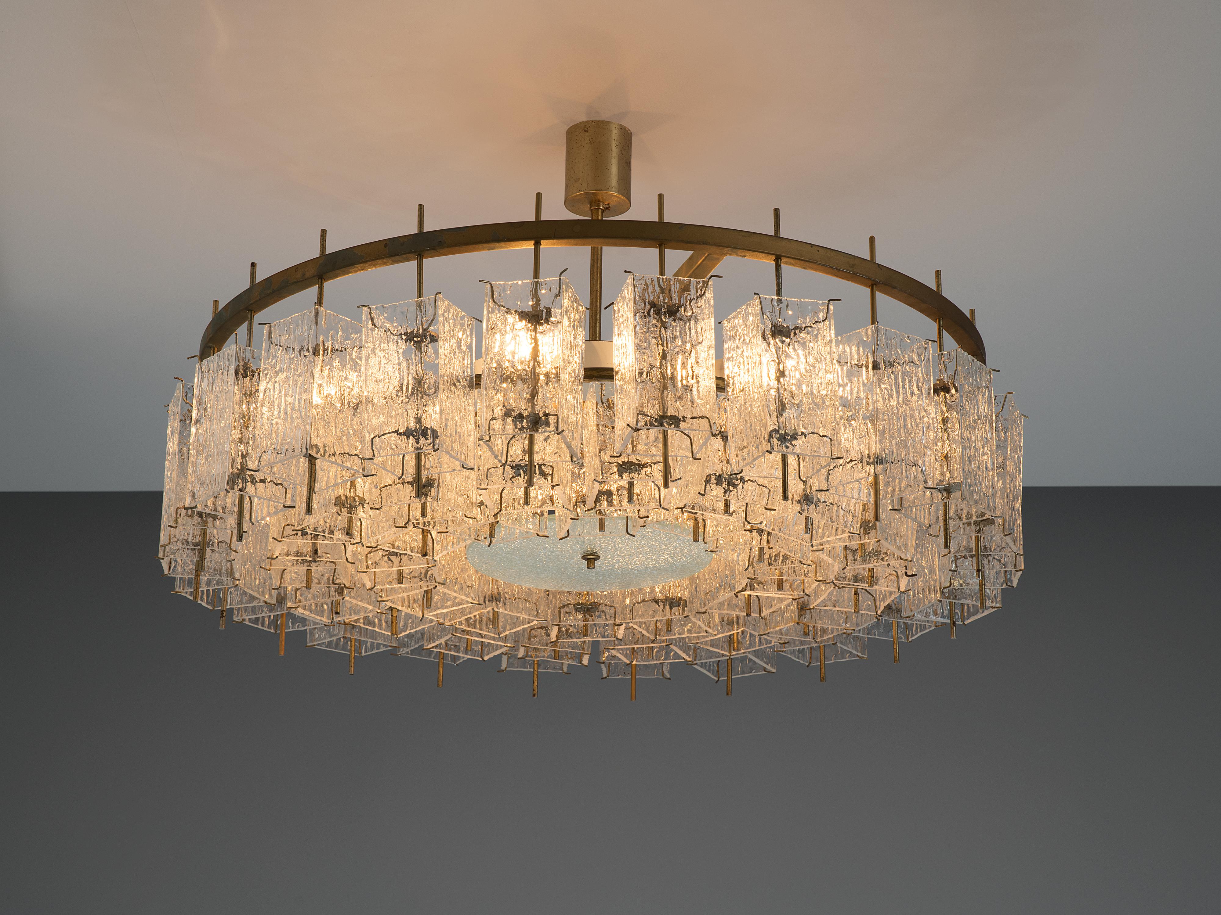 Chandelier, glass, brass, Europe, 1970s. 

Round chandelier with a great amount of rectangular structured glass shades. The frame is made of brass and holds numerous structured glass 'tubes' with a brass center. Due the combination of materials