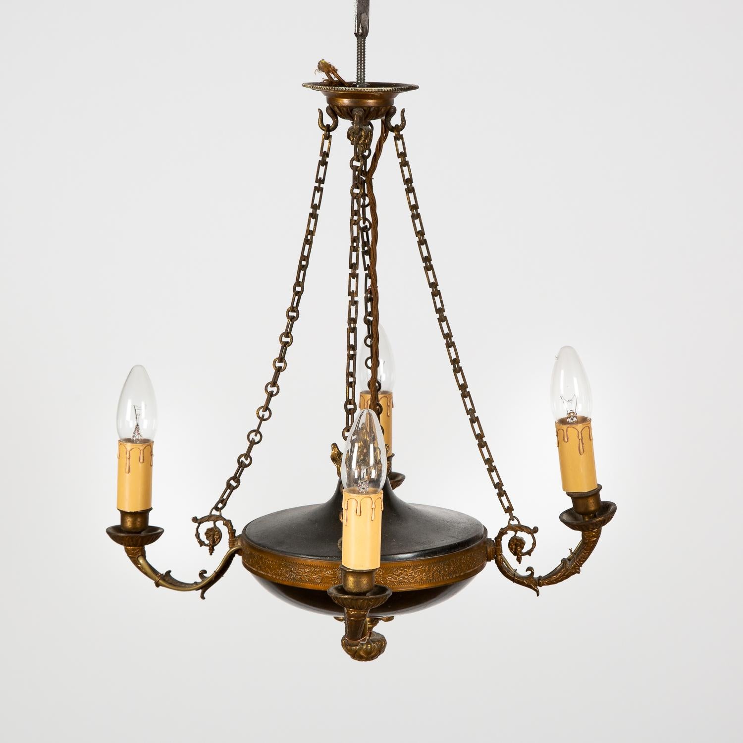 A small four light two tone chandelier in the Empire style.

 
