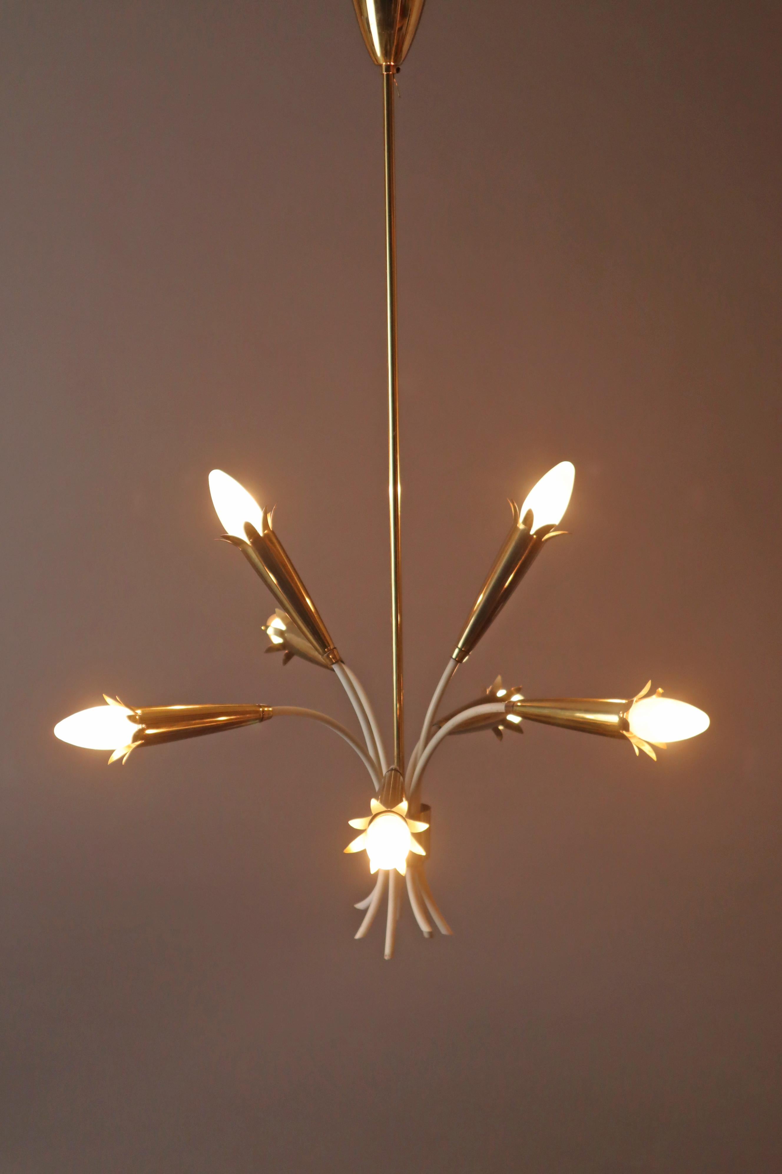 Unique chandelier in an exceptionally beautiful, simple, minimalist design, it combines modern mid-century and minimalist regency. The chandelier is made from high-quality polished brass and white lacquered accents, the E14 light bulb sockets are