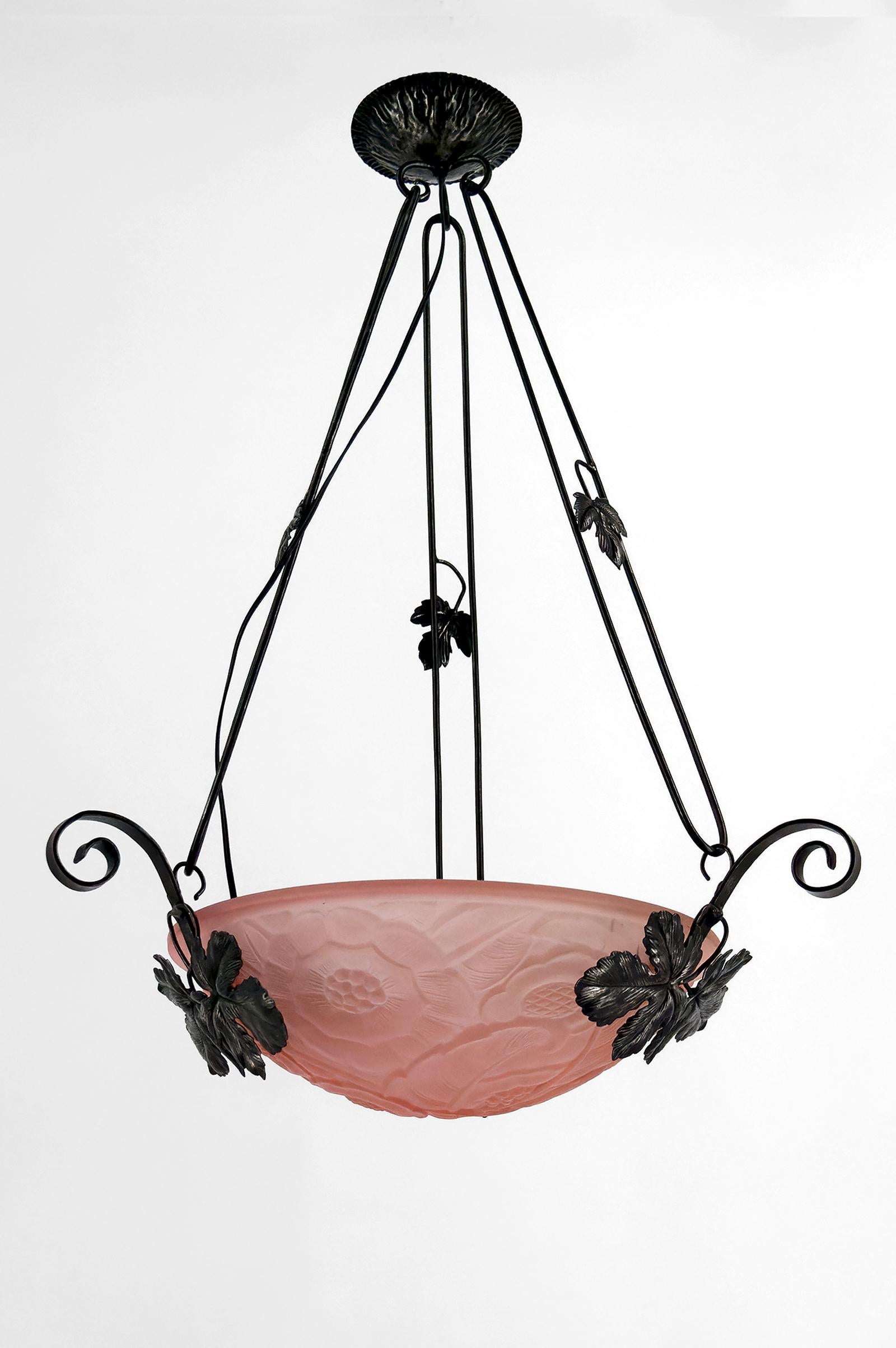 Importante Suspensión / Araña de Hierro Forjado con Decoración de Enredadera, Tazón de Vidrio Rosa Moldeado a Presión con Patrones Florales Geométricos, Art Decó, Francia, circa 1930.

Añade un toque de elegancia y refinamiento a tu interior con