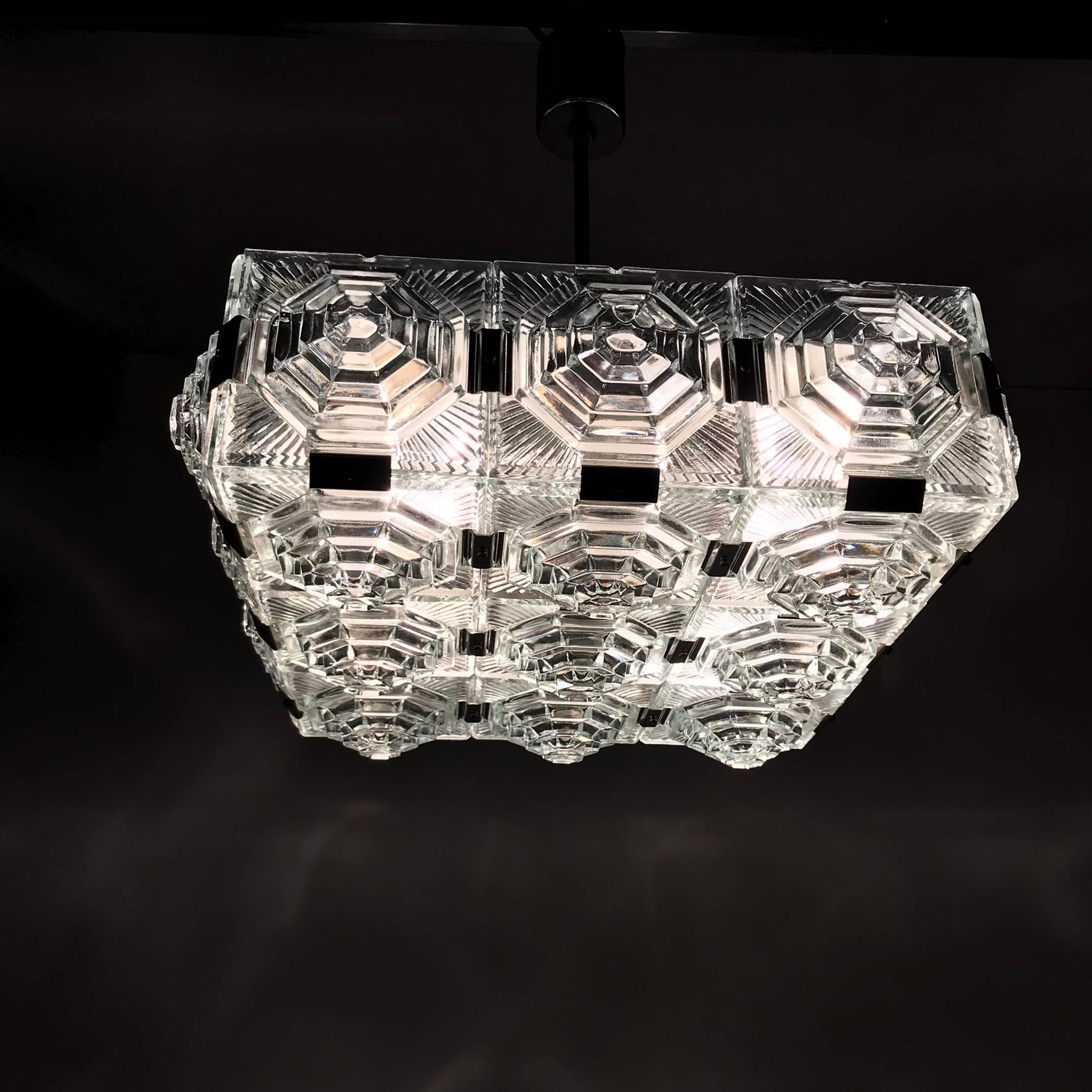The chandelier is consists of few convex glasses. The glasses are conected chrome staples. It is in very good condition with original patina. There are four E27 socket. Wiring is ready for 110 and 220V.  The parcel is excellent packed for transport.