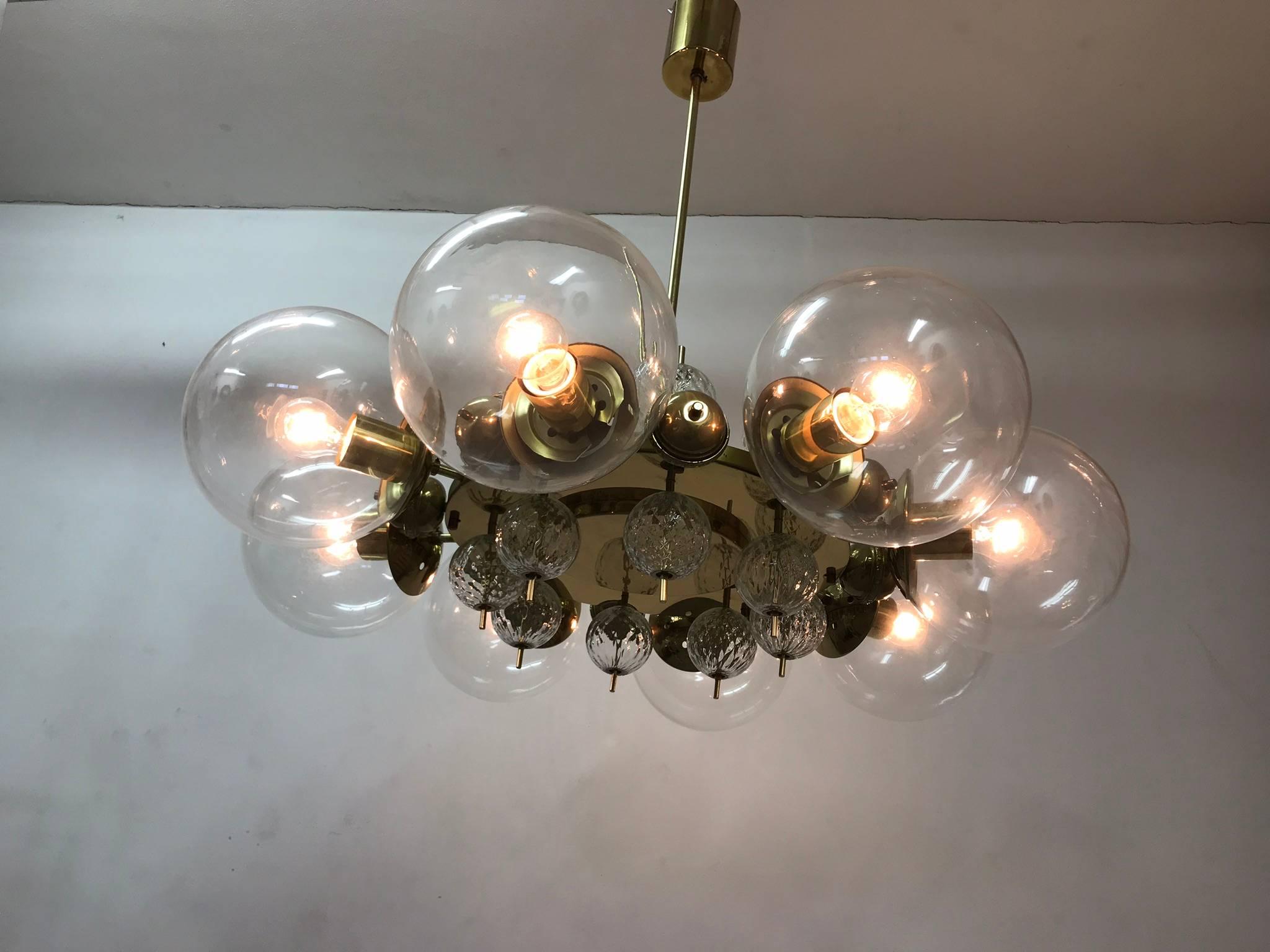 An unique chandelier from the 1965s. The brass construction is completed with the original patina. The glass balls are hand-blown. The conditions is very nice. The chandelier is fitted with eight glass spheres of 20 cm in diameter. Each arm has an