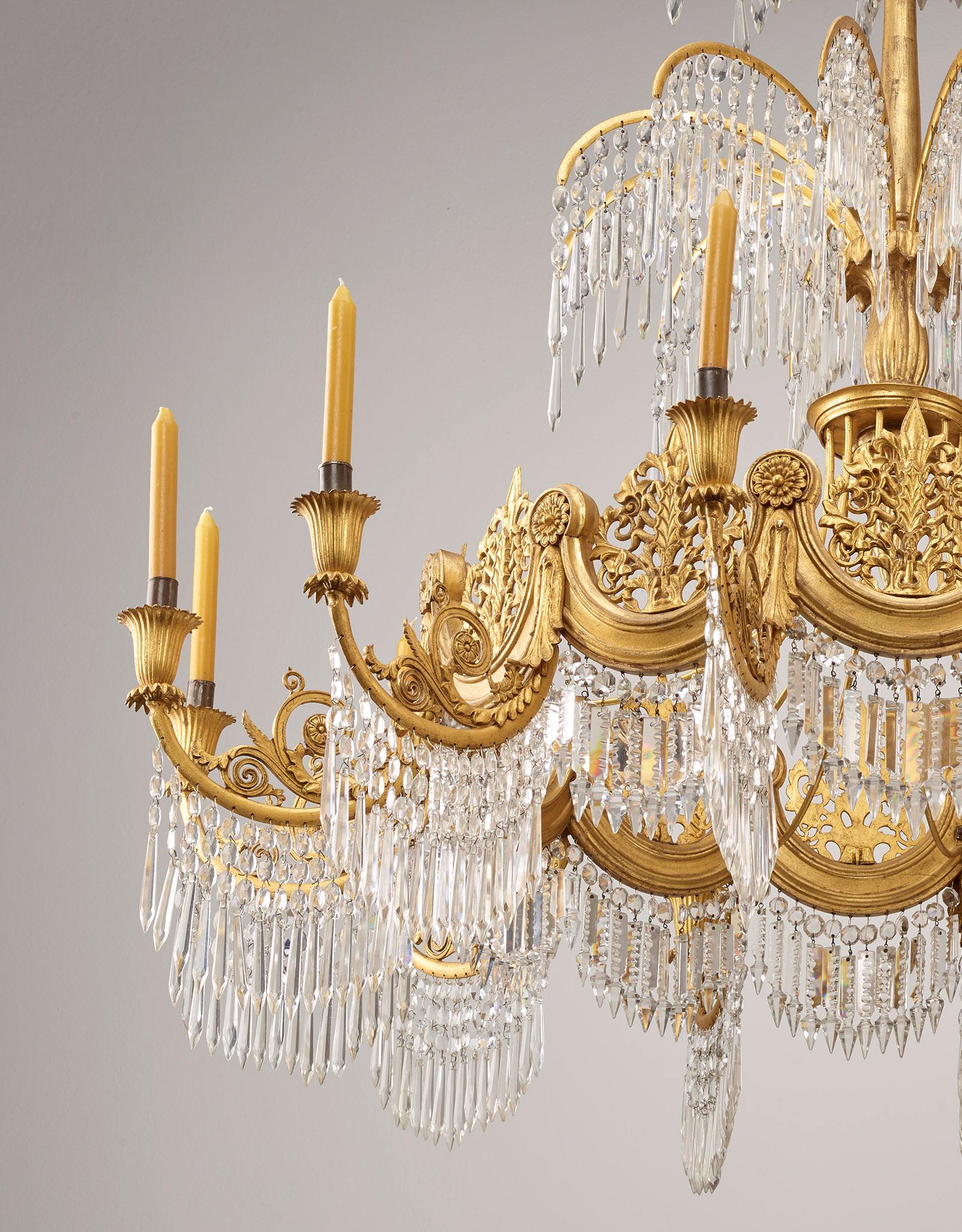 Splendid courtly chandelier based on designs by Karl Friedrich Schinkel,
Berlin, around 1835
Cast metal, wood and wood bronze, 12-arm mounted and with the original gilding and crystal glass hanging. The chandelier was probably made by the Berlin