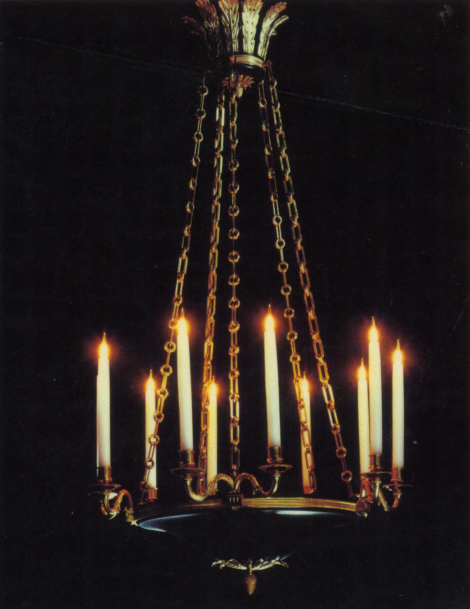 The polished brass acanthus leaf corona supports six rectangular split link chains holding a black painted bowl with an ormolu pendant. The five polished brass double candle branches fitted with Girard Sudron candle lamps.
 
 
Provenance: Chester