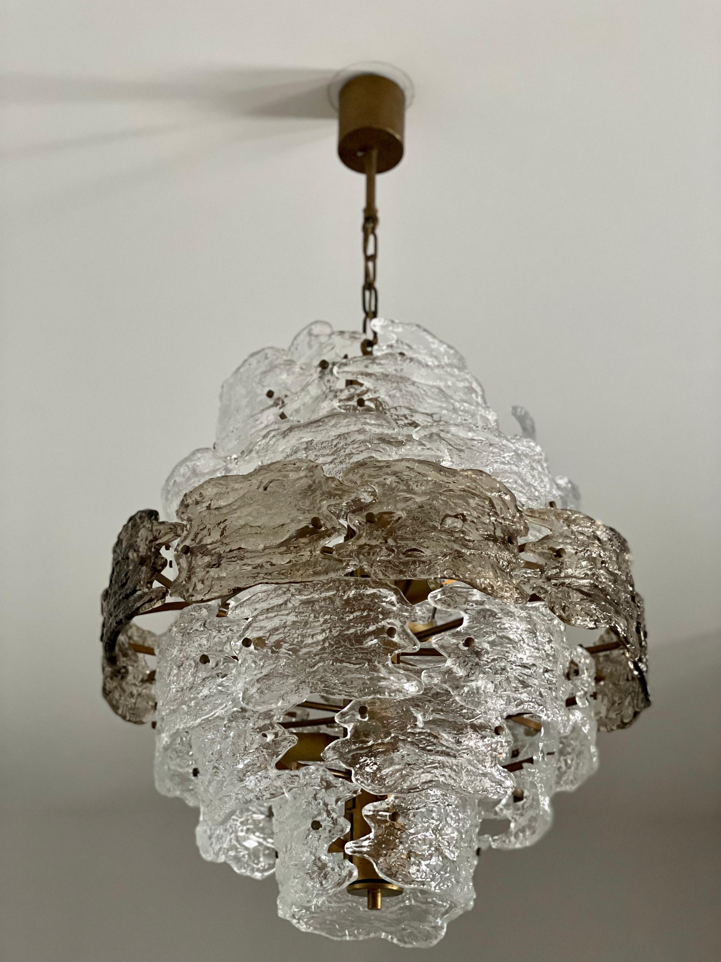 The Vintage Mazzega Chandelier, crafted with exquisite Murano glass in the 1970s, captivates with its beauty. Its remarkable form, resembling sparkling crystal, brings an element of refined luxury to the interior.

Every meticulously crafted glass