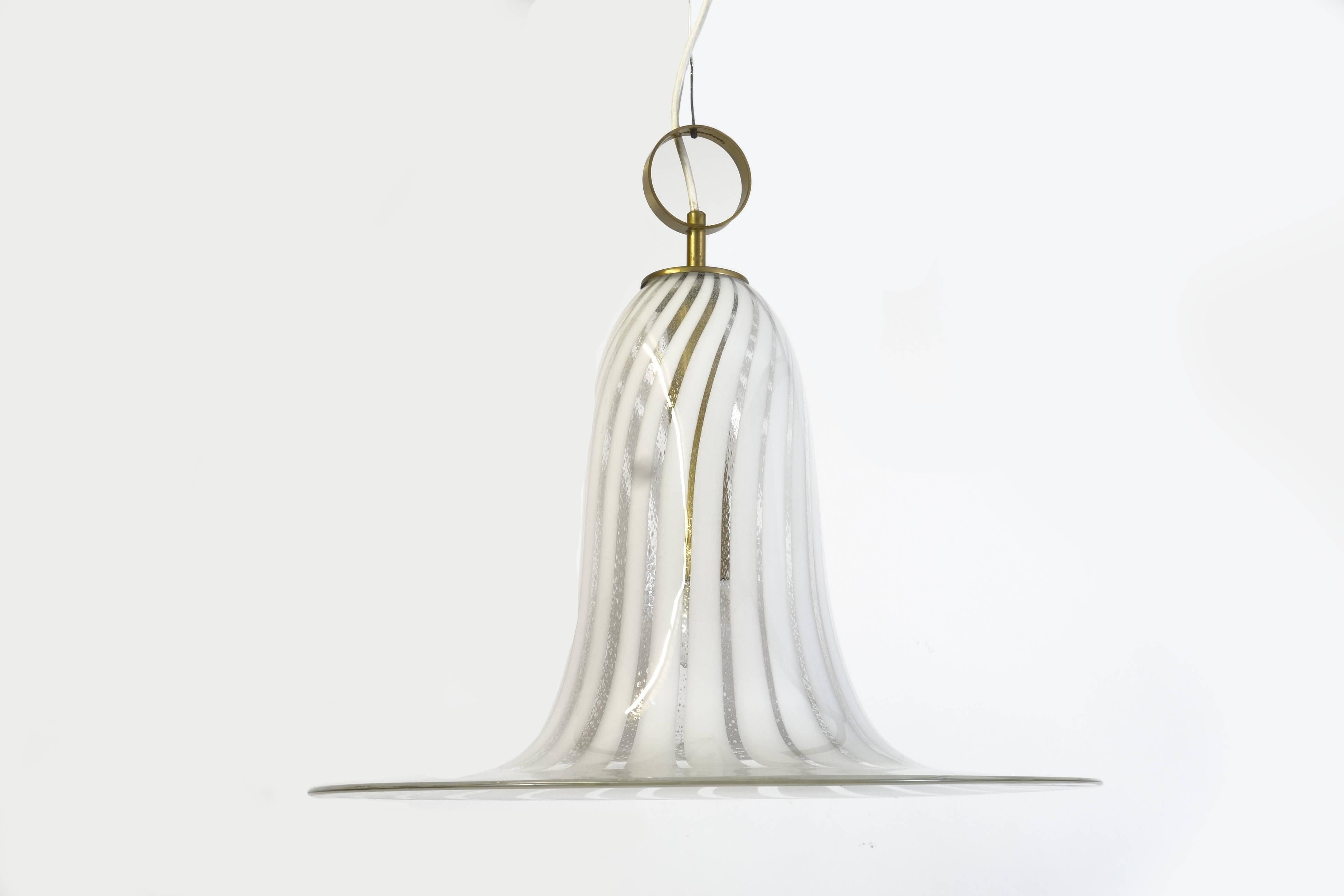 A single piece of handmade Murano glass forms the bell shape of this extraordinary chandelier of Italian origin. The object was most probably manufactured during the 1970s. The staggered stripe pattern in the glass forms an extremely attractive