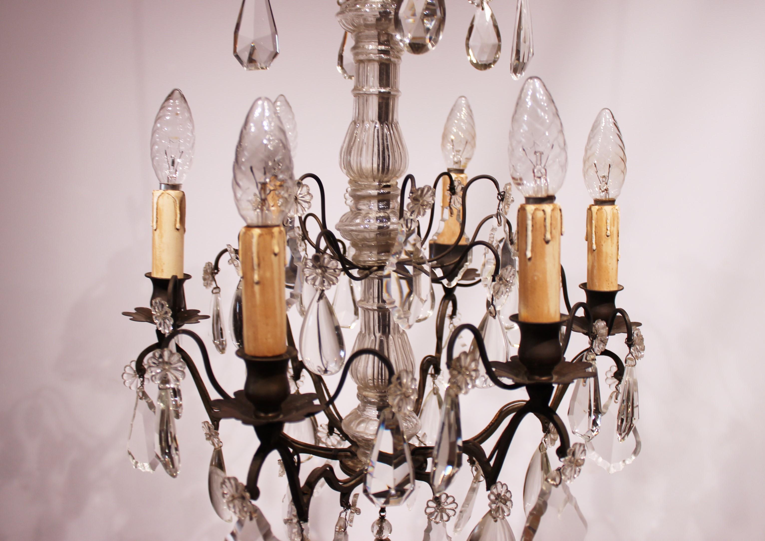 Chandelier made of brass and polished prisms. The chandelier is from France and manufactured circa 1920s. The item is in great antique condition.