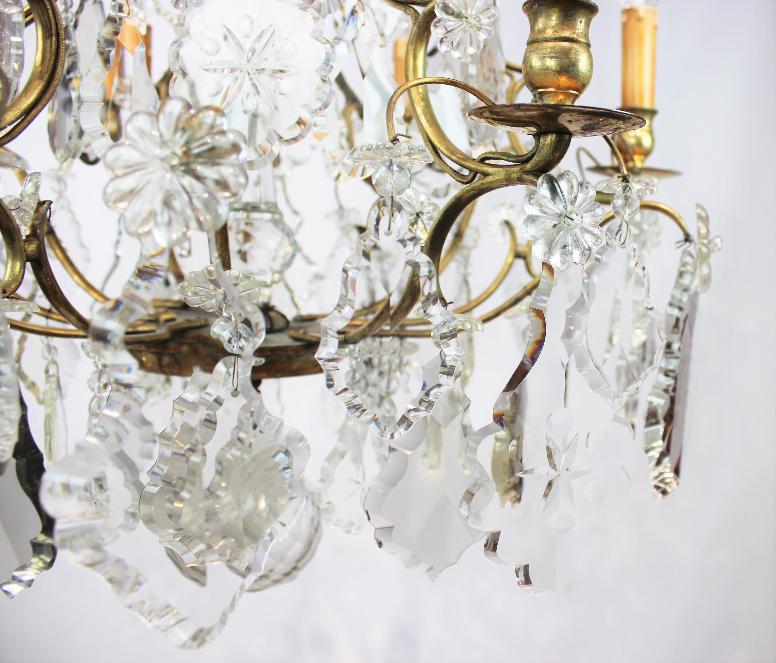 Chandelier of brass and polished prisms from France, circa 1920s. The chandelier is in great antique condition.